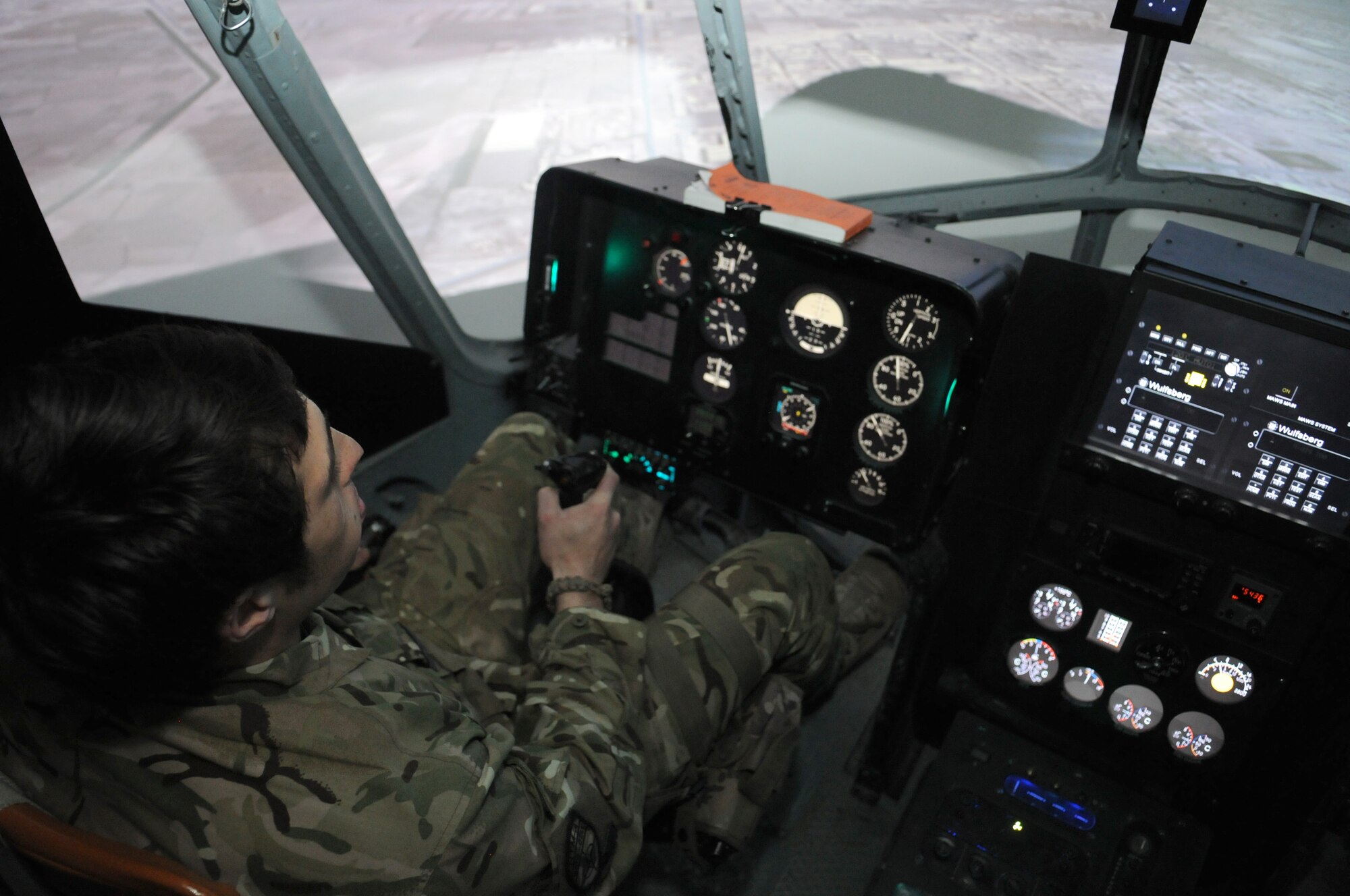 Royal Air Force Flight Lt. Tom Loucaides, 438th Air Expeditionary Wing Thunder Lab director of aviation training, demonstrates the basic control functions of an Afghan air force Mi-17 helicopter simulator during a familiarization training session, Kabul International Airport, Afghanistan, March 15, 2012. Loucaides is assigned to the 438th AEW to mentor Afghan pilot candidates through approximately 60 hours of academic instruction as well as flight screening in the Cessna 182T prior to beginning flight training. (U.S. Air Force photo by Staff Sgt. Nadine Y. Barclay)