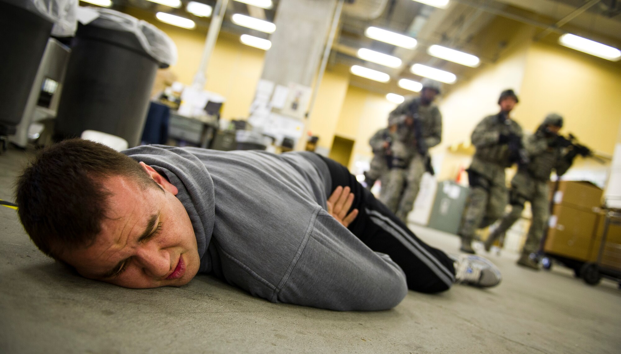 YOKOTA AIR BASE, Japan -- Senior Airman William Pressgrove, active shooter role player, lies paralyzed as 374th Security Forces patrolmen search for a shooter during an active shooter scenario March 16, 2012. Security forces personnel recieve this training annually and is designed to give them the tactics, techniques and procedures to find and neutralize a threat. (U.S. Air Force photo/Staff Sgt. Chad C. Strohmeyer)