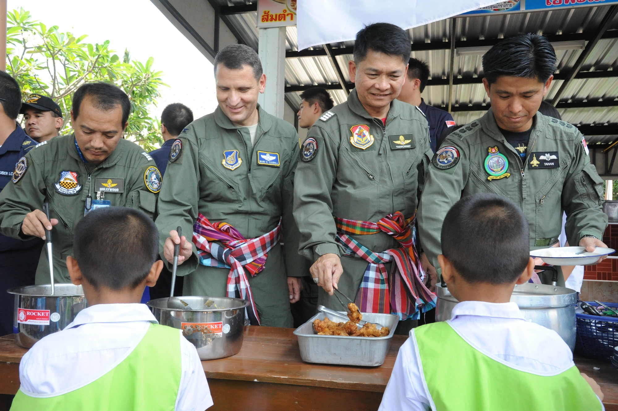 Cope Tiger exercise directors from the U.S. Air Force, Republic of Singapore Air Force and host, Royal Thai Air Force, serve lunch to students from the Watprommarat School here during a community outreach and cultural exchange event, Mar. 13. The 269-student school was visited by more than 40-Airmen from the three nations, currently participating in exercise Cope Tiger, a large force air employment exercise designed to enhance readiness and interoperability among participating nations in the Asia-Pacific region. (U.S. Air Force Photo/Capt. David Herndon)