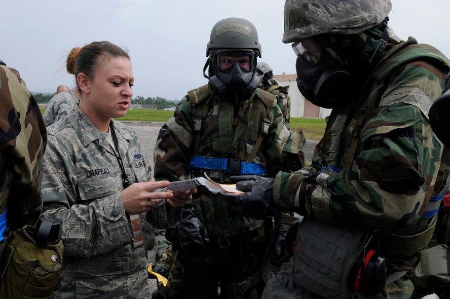 Staff Sgt. Nicole Drapeau, an exercise evaluator assigned to the 18th Maintenance Operations Squadron, checks paperwork Airmen are required to carry at all times while wearing protective equipment during local operational readiness exercise Beverly High 12-3 on Kadena Air Base, Japan, March 16, 2012. Keeping paperwork current is just one way Airmen protect themselves in LOREs and in real-world situations. (U.S. Air Force photo by Airman 1st Class Tara A. Williamson/Released)