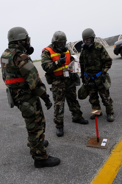 Airmen form the 67th Aircraft Maintenance Squadron reference the Airman's Manual while reporting traces of nerve gas on the mock chemical detection paper to the unit command center during local operational readiness exercise Beverly High 12-3 on Kadena Air Base, Japan, March 15, 2012. During LORE scenarios, the Airman's Manual helps Airmen find proper procedures to respond to any situation. (U.S. Air Force photo by Airman 1st Class Tara A. Williamson/Released)