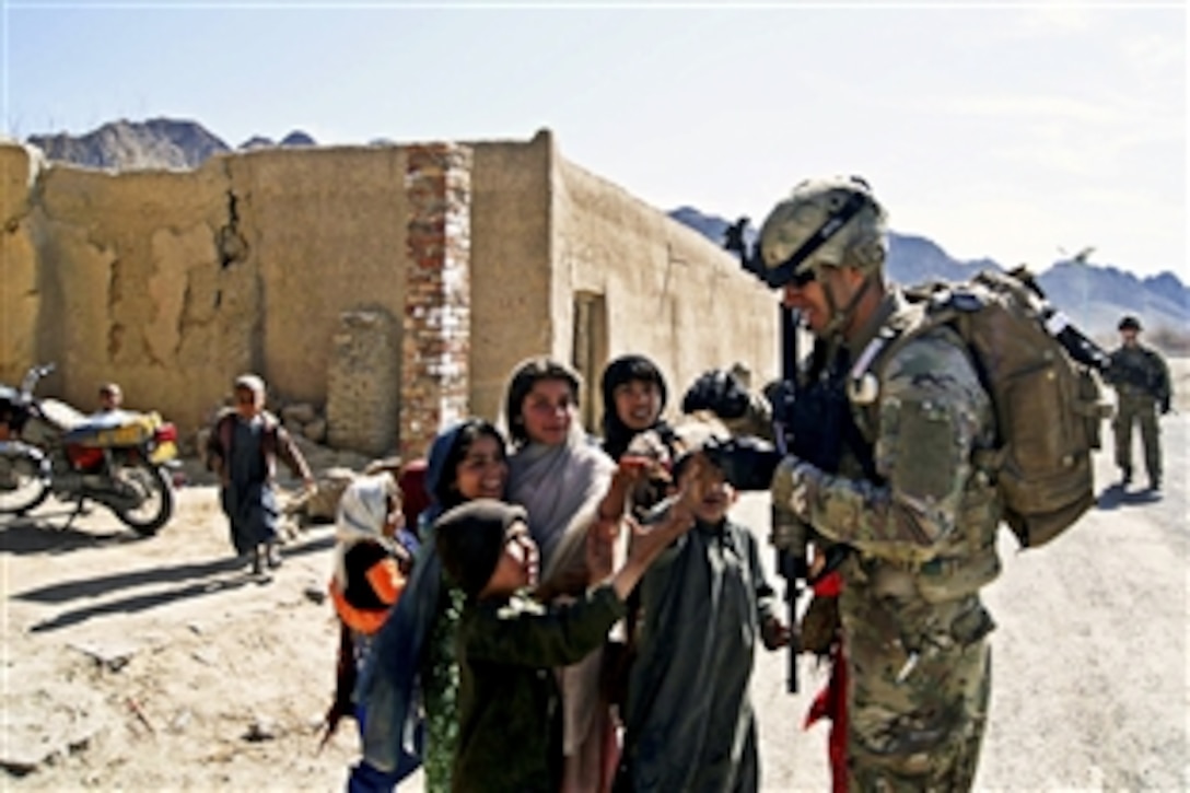 U.S. Army Sgt. Juan Almaguer hands out candy to Afghan children during a patrol to reach out to the community and meet with Afghan police near Combat Outpost Jannat, Afghanistan, March 9, 2012. Almaguer is a medic assigned to the 4th Infantry Division's Company A, 1st Battalion, 67th Armor Regiment, 2nd Brigade Combat Team.