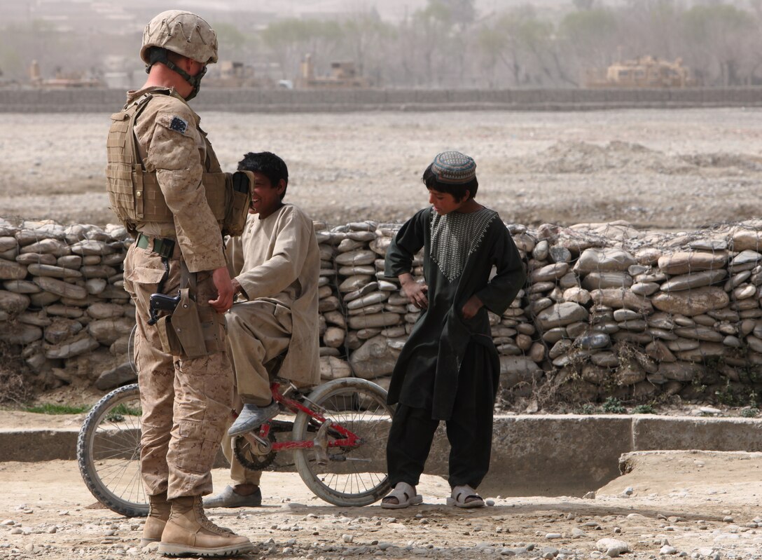 Sgt. Jacob Neuberger, a motor transport operator with General Support Motor Transport Company, Marine Air-Ground Task Force Support Battalion 11.2, 1st Marine Logistics Group (Forward) speaks to Afghan children in Musa Qal’ah, Afghanistan, March 16. The Marines with GSMT Co. have had the unique opportunity to work and interact with Afghans throughout their seven-month deployment.