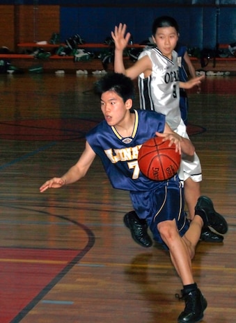 Taki Yamada, Ajina-Dai Junior High School forward, sprints with the ball into Otake Junior High School territory during a U.S. – Japan youth basketball tournament at IronWorks Gym sports courts here Saturday. The children were able to experience different cultures and gain a better understanding of each other during the games and hanging out at the Crossroads Mall afterwards.