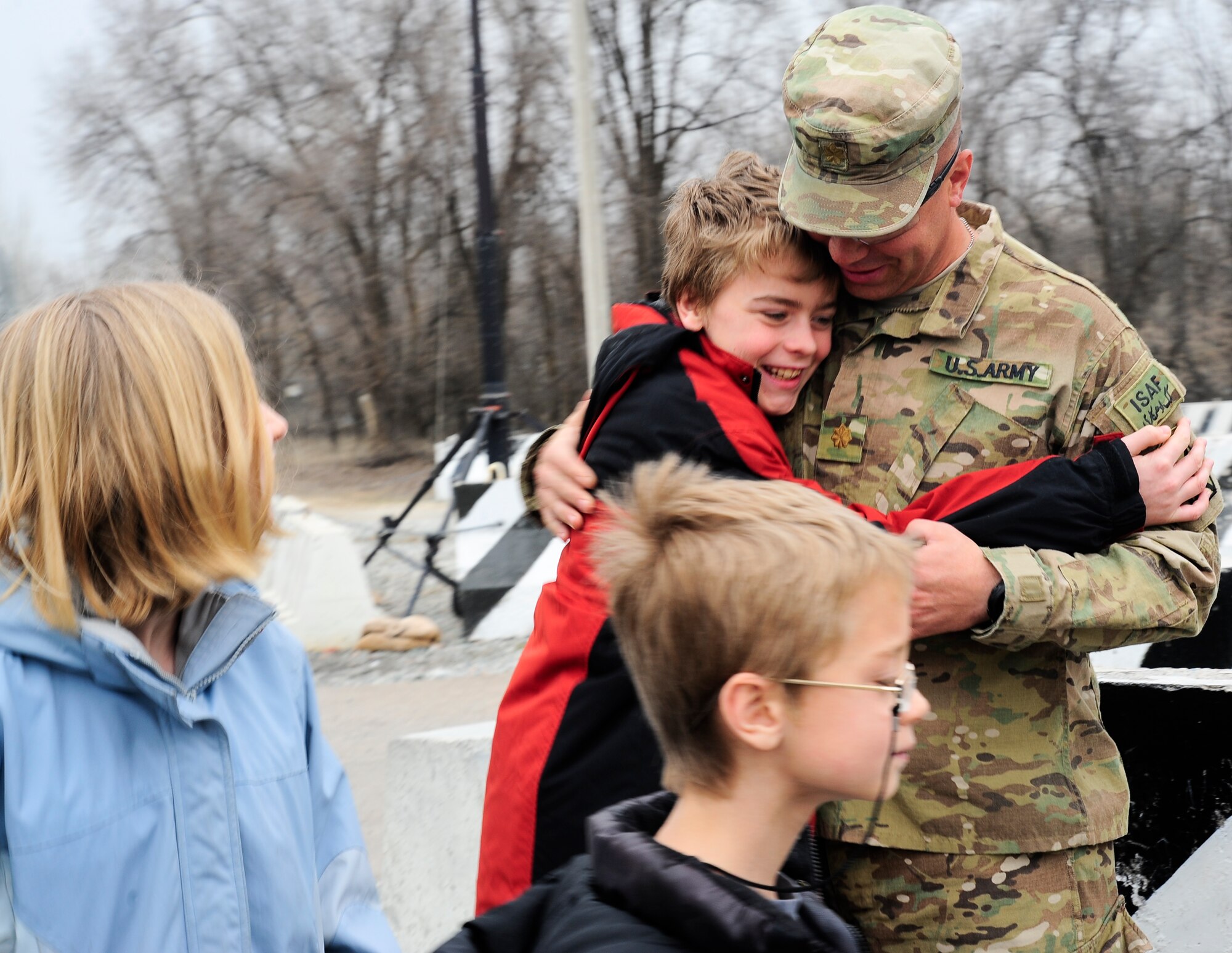 Nathan Smith hugs his uncle, Army Maj. John Womack, for the first time in a year March 16, 2012, during a short family reunion at the Transit Center at Manas, Kyrgyzstan. The Transit Center organized a few hours for the family to reunite while Womack was passing though following a 12-month deployment to Afghanistan. (U.S. Air Force photo/Staff Sgt. Angela Ruiz)