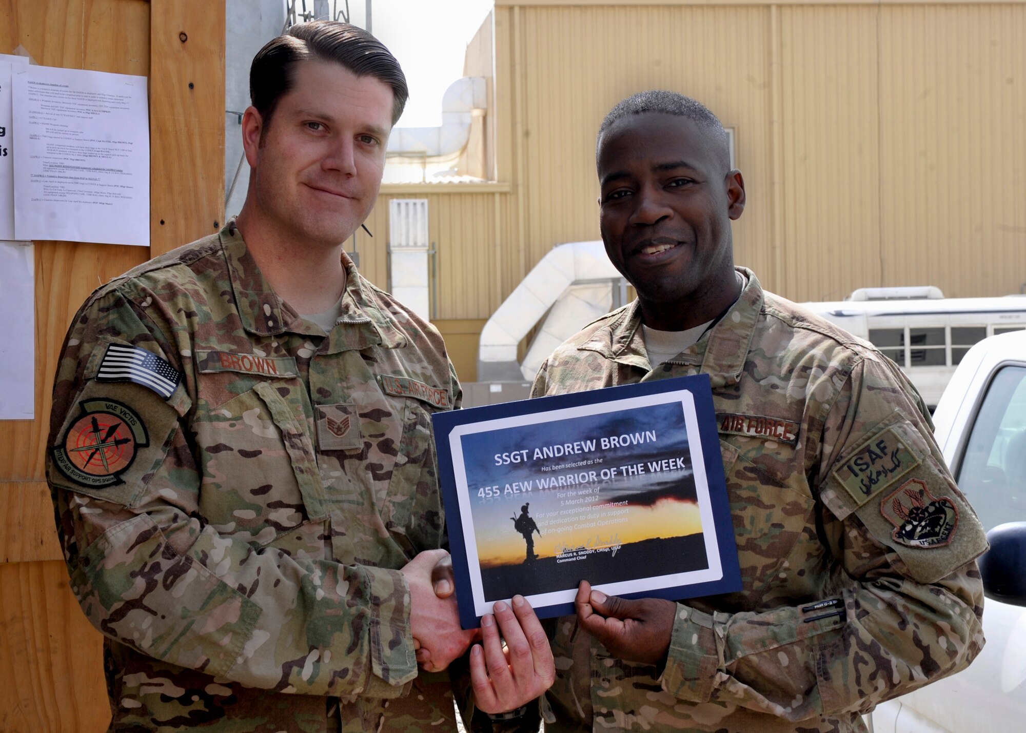 BAGRAM AIRFIELD, Afghanistan—Staff Sgt. Andrew Brown receives the Warrior of the Week award from Command Chief Master Sgt. Marcus Snoddy at Bagram Airfield, Afghanistan, March 17, 2012. Brown is the noncommissioned officer in charge of vehicle operations and earned the Warrior of the Week award for his hard work and dedication to excellence. (U.S. Air Force photo/Airman 1st Class Ericka Engblom)