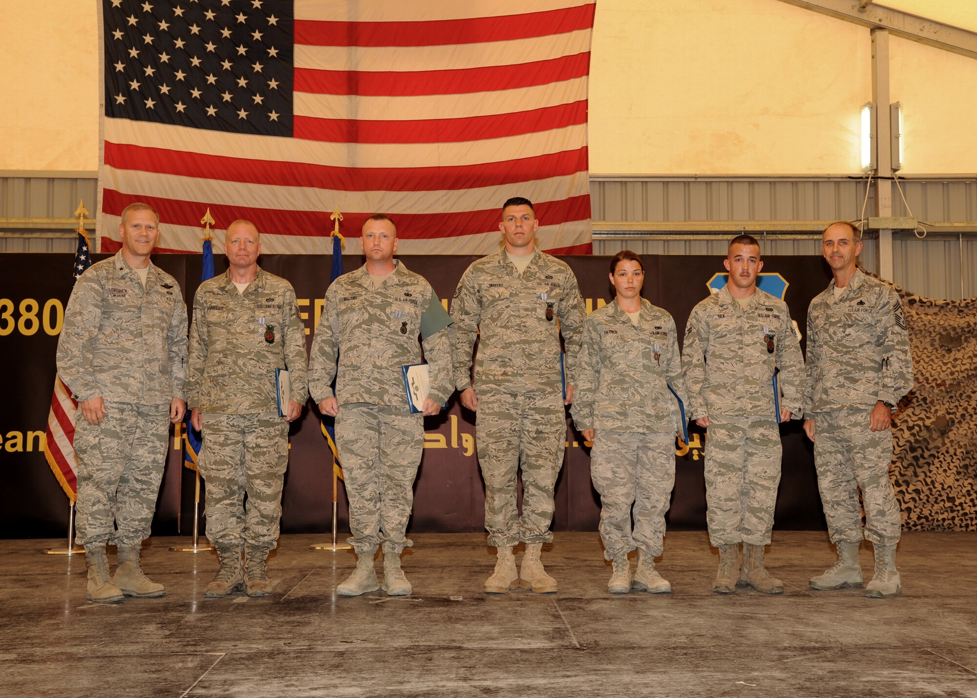 SOUTHWEST ASIA -  Brig. Gen. Jeff Lofgren, 380th Air Expeditionary Wing commander, honors five Airmen assigned to the 380th AEW with Air Force Achievement medals for their role in saving the life of a fellow Airman. The Airmen used their CPR and self-aid and buddy care training to help rescue an Airman who collapsed during a run. (U.S. Air Force photo/Tech. Sgt. Arian Nead)