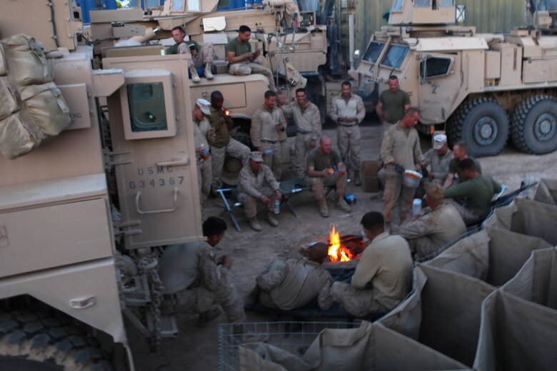 Marines with General Support Motor Transport Company, Marine Air-Ground Task Force Support Battalion 11.2, 1st Marine Logistics Group (Forward) relax by a fire at Forward Operating Base Edinburgh after the completion of a mission, March 17. Since the Marines came from various reserve stations throughout the U.S., many of them met for the first time during predeployment training. However, the company performed like they had been together for years.