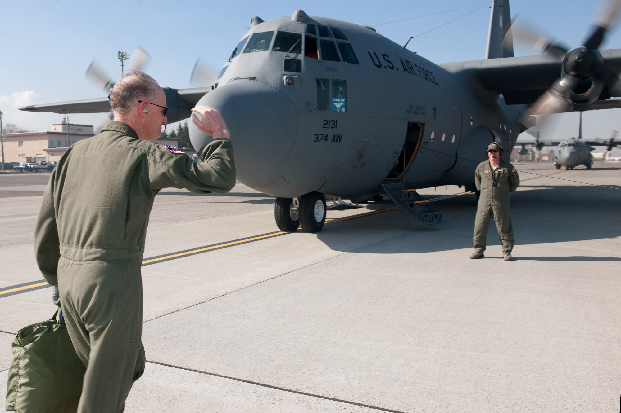 YOKOTA AIR BASE, Japan -- Col. Otto Feather (left), salutes before boarding a C-130 Hercules at Yokota Air Base, Japan, March 15, 2012 during his final flight. Known as the "fini flight," military aviators have a tradition where after completion of their final flight, aircrew members are met and hosed down with water by their squadron comrades, family and friends. (U.S. Air Force photo/Osakabe Yasuo)