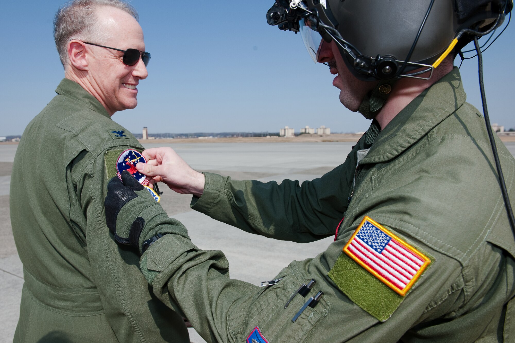 YOKOTA AIR BASE, Japan -- Staff Sgt. Andrew Schloemer (right), 459th Airlift Squadron flight engineer, attaches a 459AS patch on Col. Otto Feather (left), 374th Airlift Wing commander, during Colonel Feather's final flight at Yokota Air Base, Japan, March 15, 2012. Known as the "fini flight," military aviators have a tradition where after completion of their final flight, aircrew members are met and hosed down with water by their squadron comrades, family and friends. (U.S. Air Force photo/Osakabe Yasuo)