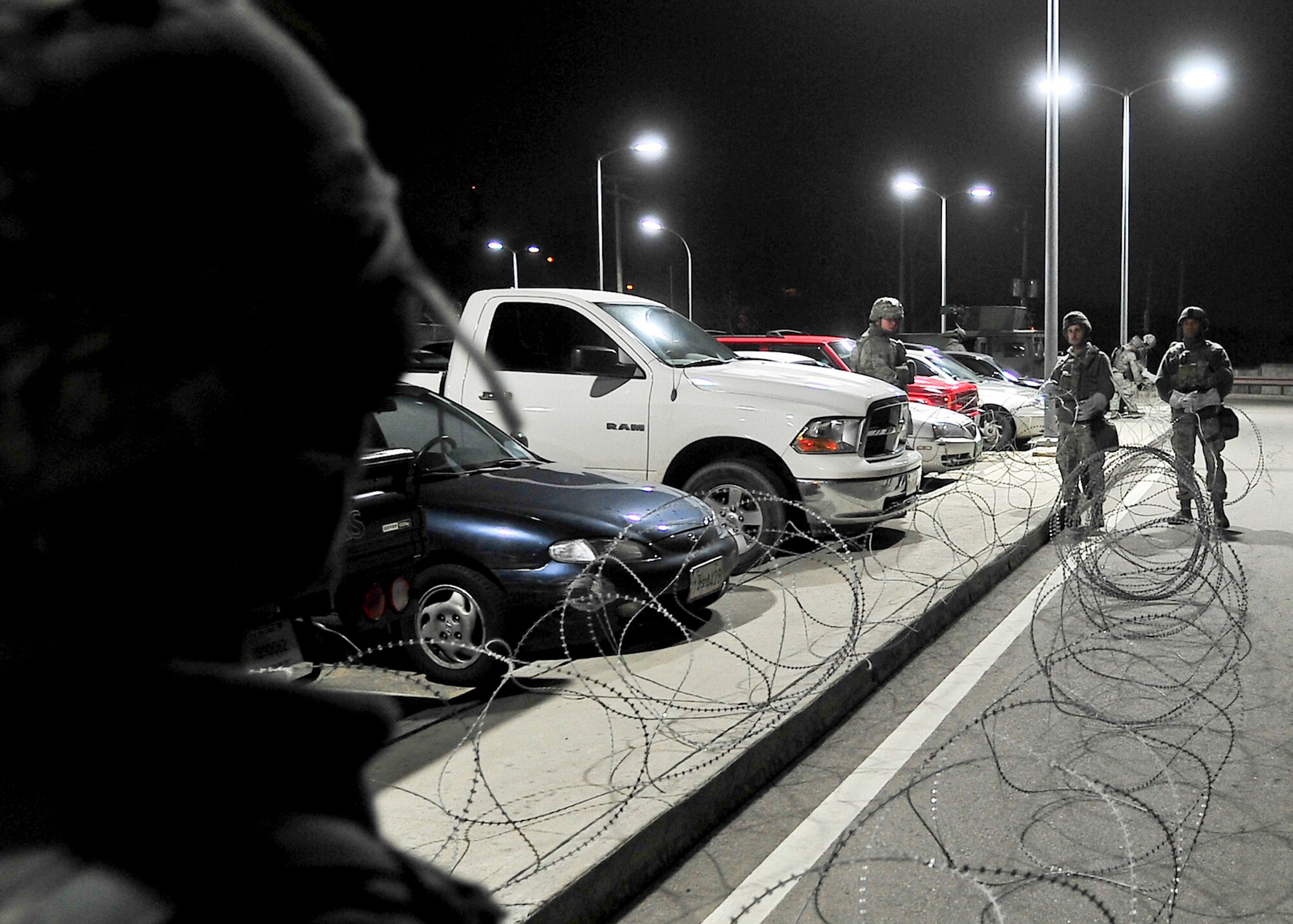 As threat levels rise, members of the 51st Security Forces Squadron and base augmentees place concertina wire around the base, March 18, 2012, during exercise Beverly-Midnight 12-01. Exercises like this test Osan Airmen's ability to survive and operate in a wartime environment and also tests their ability to plan and execute an exercise. (U.S. Air Force photo/Senior Airman Adam Grant)