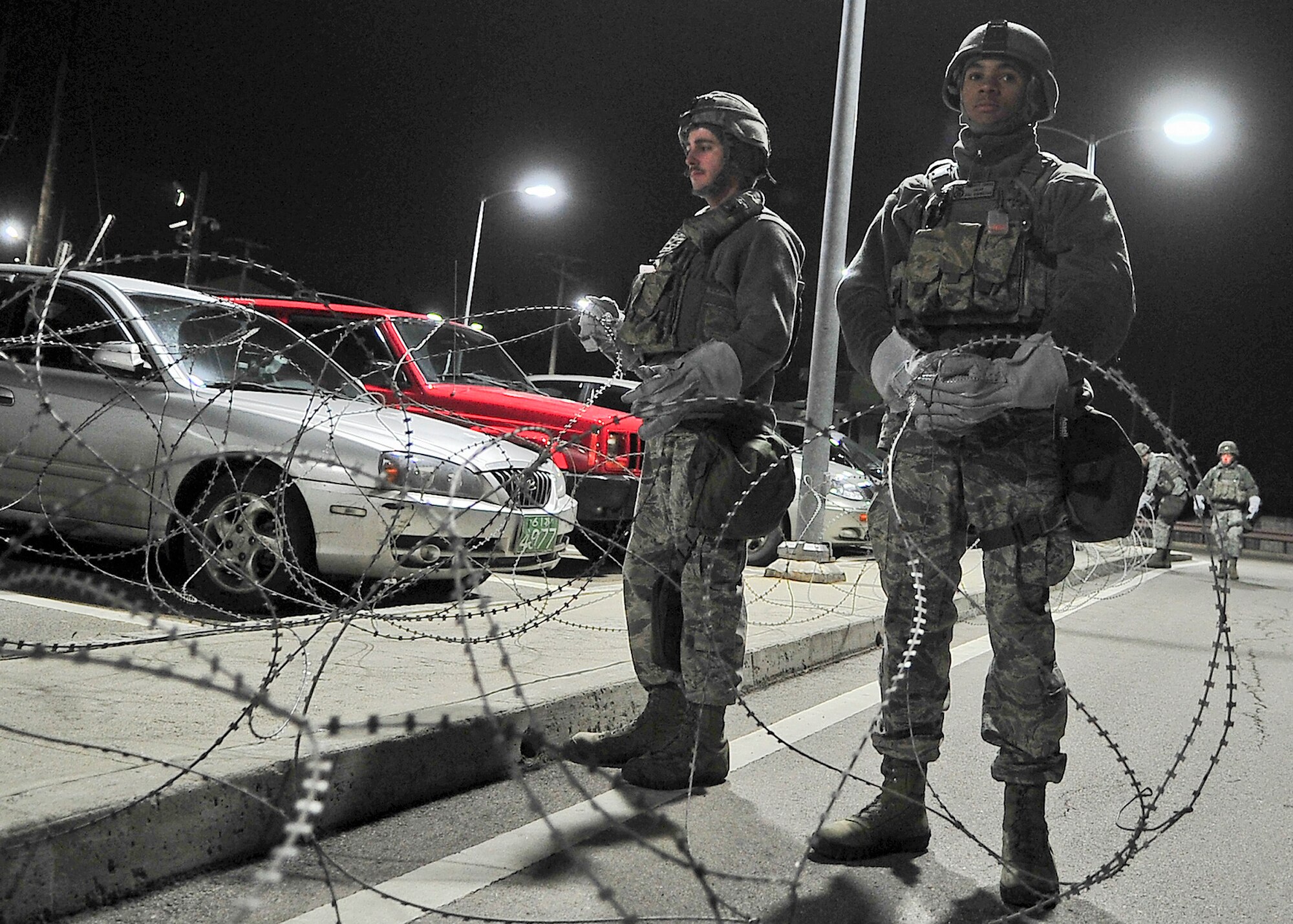 51st Security Forces Squadron and base augmentees set up concertina wire around the base, March 18, 2012, during exercise Beverley-Midnight 12-01. Exercises like this test Osan Airmen's ability to survive and operate in a wartime environment and also tests their ability to plan and execute an exercise. (U.S. Air Force photo/Senior Airman Adam Grant)