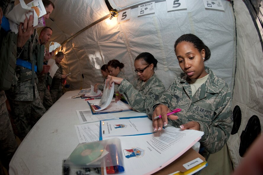 U.S. Air Force Staff Sgt. Esperanza Raymond (right), 136th Airlift Wing, Logistics Readiness Squadron, reviews documentation during an Operational Readiness Inspection processing station check point, Naval Air Station Fort Worth, Joint Reserve Base, Texas, March 18, 2012. Members of the 136  AW prepare to deploy for their Operational Readiness Inspection. (National Guard photo by Tech. Sgt. Charles Hatton)