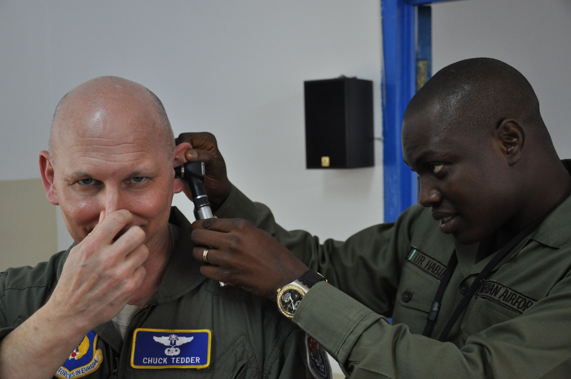 ACCRA, Ghana -- Col. Chuck Tedder, U.S. Air Forces Africa chief of medical readiness, performs the Valsalva maneuver, while Nigerian air force Flying Officer Roy Umar Habib, a military doctor, watches for movement of his ear drum during the aerospace medicine portion of African Partnership Flight here March 14. The maneuver, which is commonly used to pop a person’s ears from changes in altitude, is part of U.S. Air Force flight physicals. (U.S. Air Force by Staff Sgt. Brok McCarthy/released)