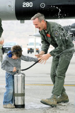 U.S. Air Force Brig. Gen. Terrence O'Shaughnessy, 57th Wing commander, is sprayed with a fire extinguisher by his son, Sam, following his last flight as wing commander March 16, 2012, at Nellis Air Force Base, Nev. O'Shaughnessy has completed more than 3,000 flight hours in the F-16 Fighting Falcon. (U.S. Air Force photo by Staff Sgt. Christopher Hubenthal)