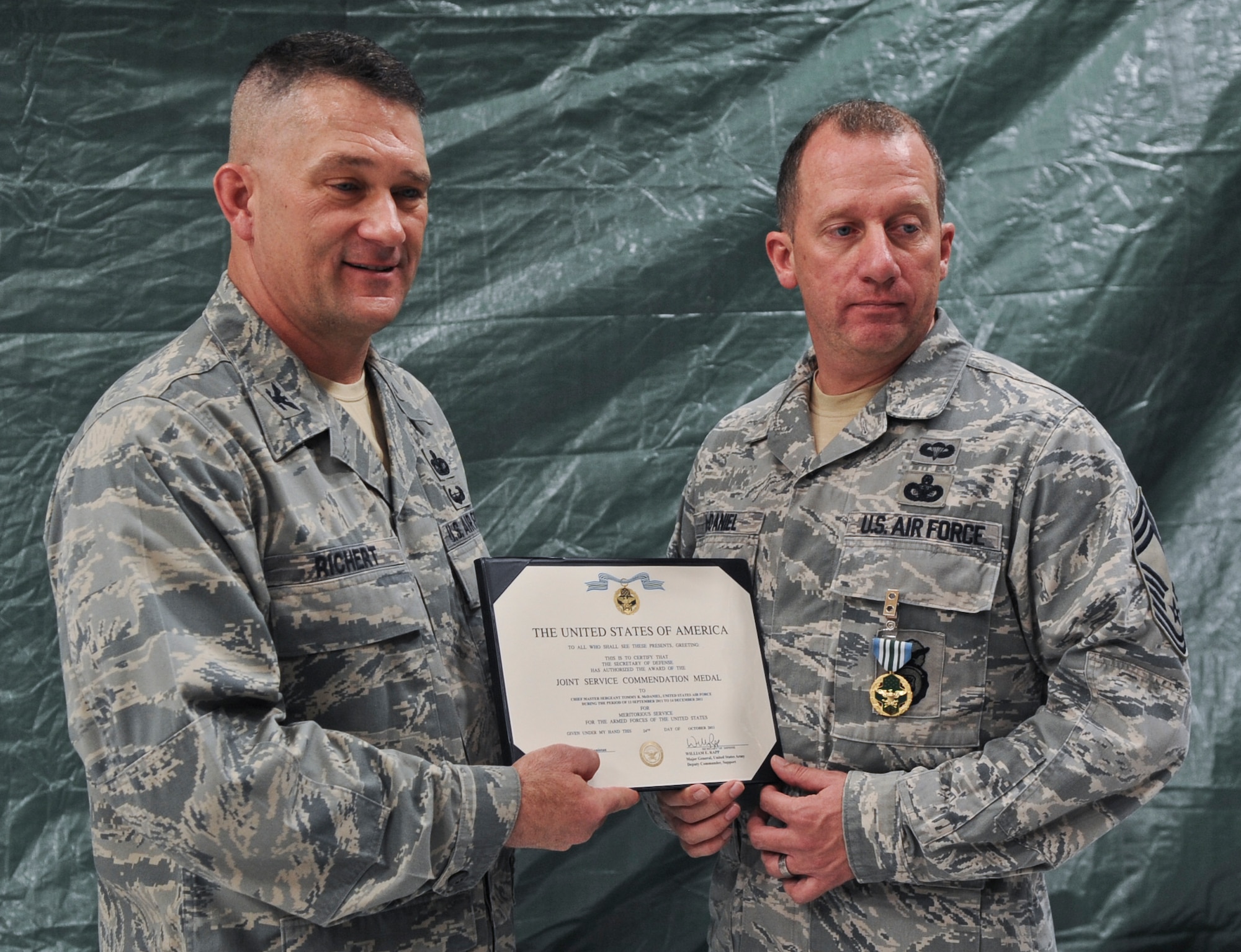 U.S. Air Force Col. Randall Richert, 820th Base Defense Group commander, awards the Joint Service Commendation medal to Chief Master Sgt. Tommy McDaniel, 820th Base Defense Group superintendent, during the 15-year anniversary ceremony at Moody Air Force Base, Ga., March 16, 2012. During the ceremony, various medals earned during deployments were presented to members of the unit. (U.S. Air Force photo by Airman 1st Class Olivia Dominique/Released)