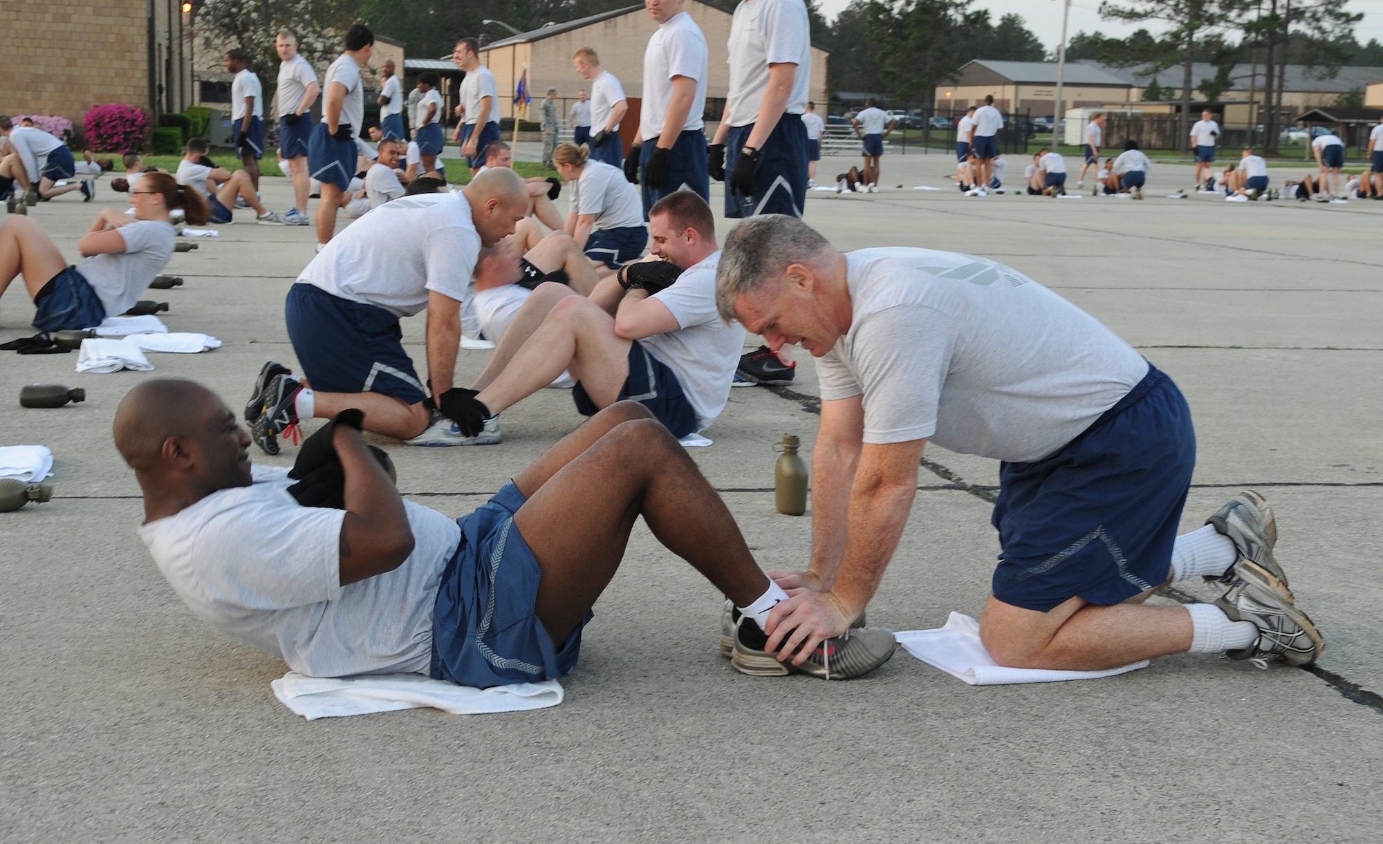 U.S. Air Force Col. Paul Walski, 93d Air Ground Operations Wing vice commander, assists Senior Master Sgt. Johnny Gavin, 824th Base Defense Squadron operations superintendent, in standard Air Force sit-ups during “Sergeant Rock” physical training at Moody Air Force Base, Ga., March 16, 2012. The 820th Base Defense Group celebrated its 15th anniversary by doing a physical training session, which includes push-ups, sit-ups and a 5k run. (U.S. Air Force photo by Airman 1st Class Olivia Dominique/Released)