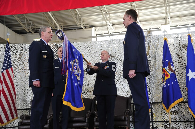 Chief Master Sgt. Earl Hannon, former 21st Expeditionary Mobility Task Force command chief, prepares the 21st EMTF flag for inactivation with Lt. Gen. Mark Ramsay, 18th Air Force commander, Maj. Gen. William Bender, U.S. Air Force Expeditionary Center commander, and Brig. Gen. Scott Goodwin, former 21st EMTF commander, during a ceremony at Joint Base McGuire-Dix-Lakehurst’s Global Reach Deployment Center March 19. The inactivation of the 21st EMTF and administrative transfer of the its subordinate units, the 621st Contingency Response Wing and the 521st Air Mobility Operations Wing, to the EC is part of an Air Mobility Command restructuring initiative. (U.S. Air Force photo by Tech. Sgt. Parker Gyokeres/released)