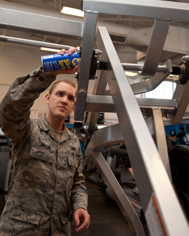 Senior Airman John Baller, 28th Force Support Squadron fitness specialist, applies lubricating silicone spray to fitness equipment during routine maintenance at the Bellamy Fitness Center on Ellsworth Air Force Base, S.D., March 13, 2012. The equipment is maintained weekly to ensure it operates properly which also extends the life of all the equipment at the center. (U.S. Air Force photo by Airman 1st Class Alystria Maurer/Released)