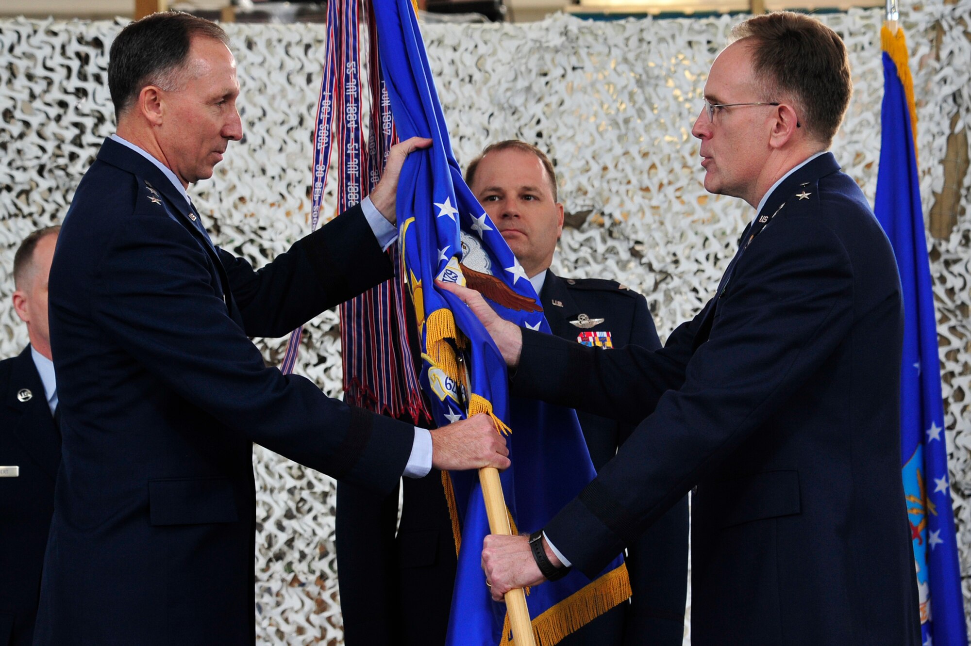 Col. Chris Patterson, 621st Contingency Response Wing commander, watches as Brig. Gen. Scott Goodwin, former 21st Expeditionary Mobility Task Force commander, transfers administrative  command of the 621st CRW to Maj. Gen. William Bender, U.S. Air Force Expeditionary Center commander, during the inactivation ceremony for the 21st EMTF at the Joint Base McGuire-Dix-Lakehurst’s Global Reach Deployment Center March 19. The inactivation of the 21st EMTF and administrative transfer of the its subordinate units, the 621st Contingency Response Wing and the 521st Air Mobility Operations Wing, to the EC is part of an Air Mobility Command restructuring initiative. (U.S. Air Force photo by Tech. Sgt. Parker Gyokeres/released)