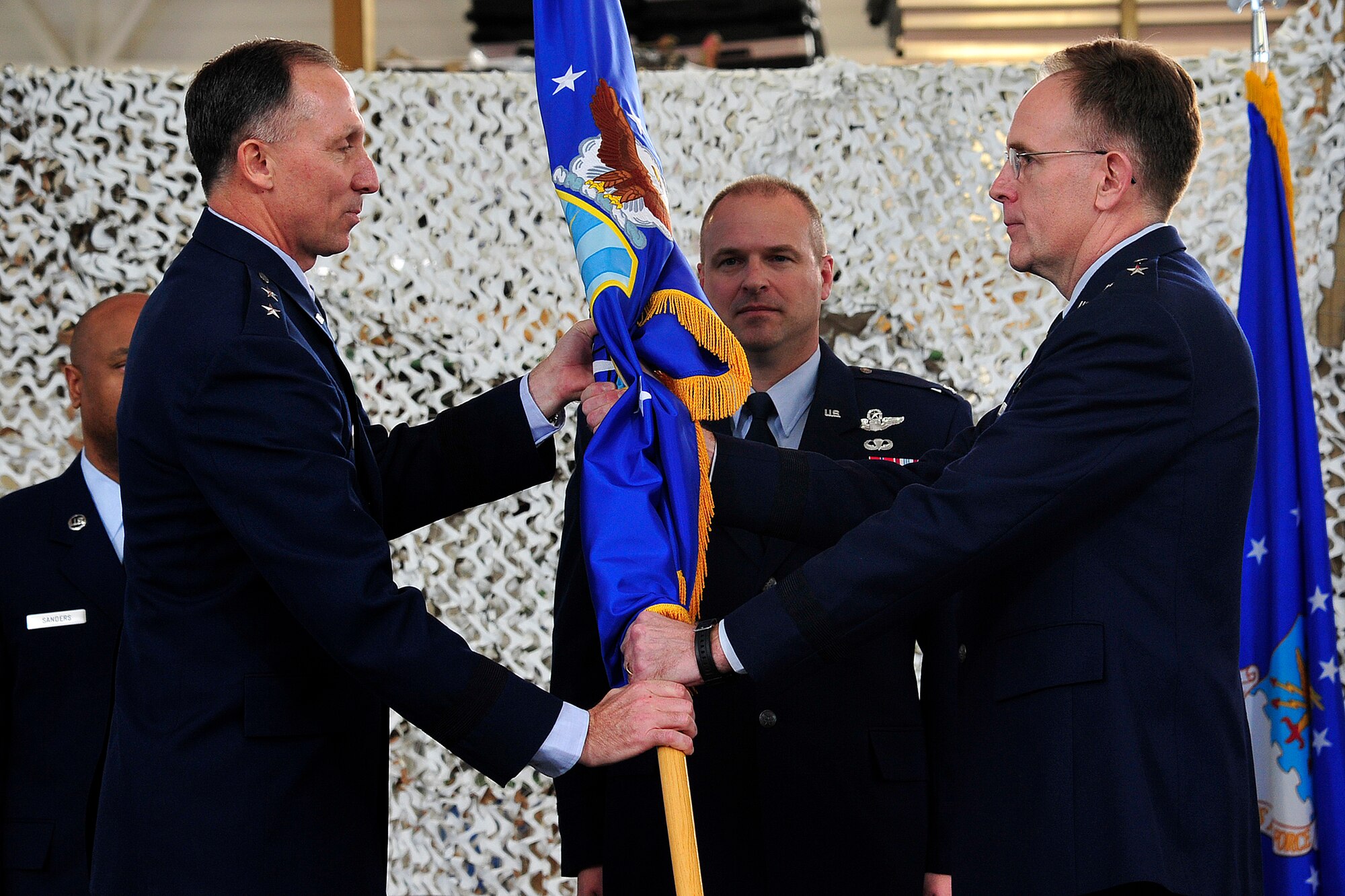 Col. Kip Turain, 521st Air Mobility Operations Wing commander, watches as Brig. Gen. Scott Goodwin, former 21st Expeditionary Mobility Task Force commander, transfers administrative command of the 521st AMOW to Maj. Gen. William Bender, U.S. Air Force Expeditionary Center commander, during the inactivation ceremony for the 21st EMTF at Joint Base McGuire-Dix-Lakehurst’s Global Reach Deployment Center March 19. The inactivation of the 21st EMTF and administrative transfer of the its subordinate units, the 621st Contingency Response Wing and the 521st AMOW, to the EC is part of an Air Mobility Command restructuring initiative. (U.S. Air Force photo by Tech. Sgt. Parker Gyokeres/released)