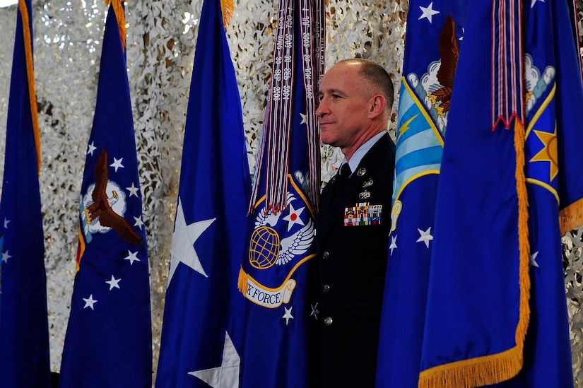 Chief Master Sgt. Earl Hannon, former 21st Expeditionary Mobility Task Force command chief, stands onstage with his unit's colors during the inactivation ceremony for the 21st EMTF at Joint Base McGuire-Dix-Lakehurst’s Global Reach Deployment Center March 19.  The inactivation of the 21st EMTF and administrative transfer of the its subordinate units, the 621st Contingency Response Wing and the 521st Air Mobility Operations Wing, to the EC is part of an Air Mobility Command restructuring initiative. (U.S. Air Force photo by Tech. Sgt. Parker Gyokeres/released)