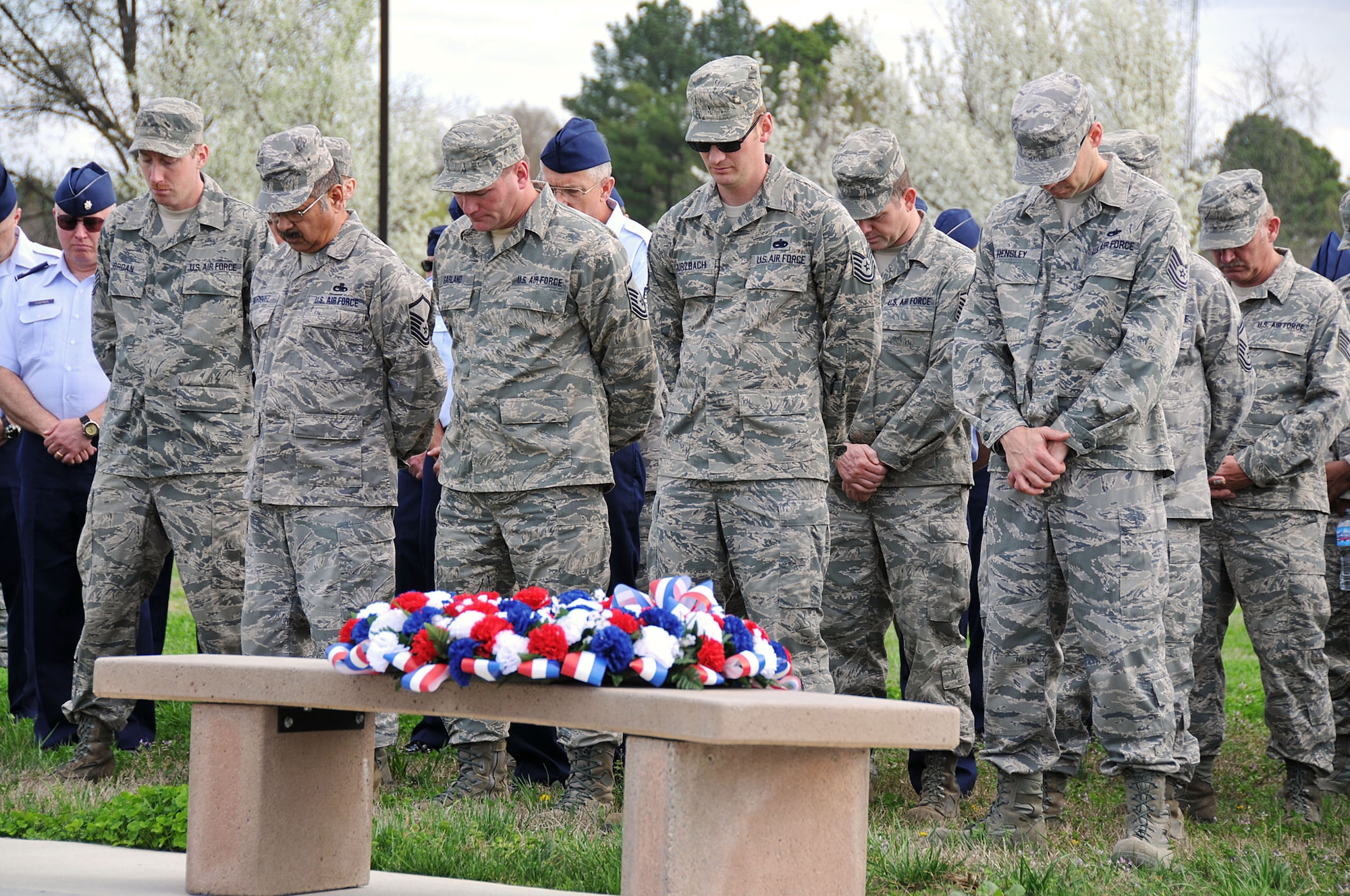 Members of the 126th Air Reufeling Wing, Illinois National Guard, bow their heads during a prayer in front of a memorial at Scott AFB, Ill., on March 19, 2012. A ceremony was held to commemorate the four Wing aircrew members who perished in an aircraft accident 30 years ago. Maj. William S. Dixon, Jr., Capt. Kenneth L. Herrick, Capt. Robert J. Nicosia and Master Sgt. Richard A. Crome were aboard a KC-135A "Stratotanker" while on a routine training mission when their plane exploded near Greenwood, Ill. In addition, 23 members of the 928th Tactical Airlift Group, Air Force Reserves, who were passengers also lost their lives. (National Guard photo by Master Sgt. Ken Stephens)