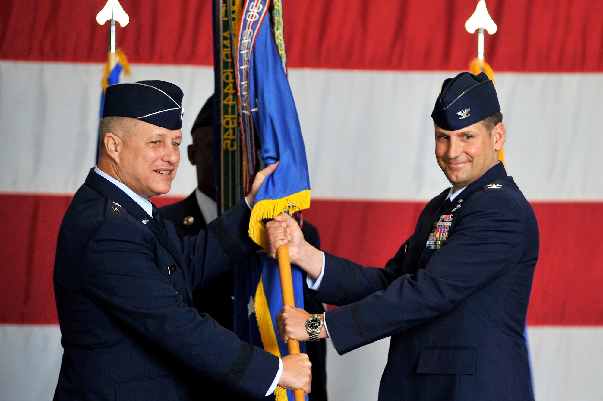 U.S. Air Force Maj. Gen. Lawrence Wells, 9th Air Force commander, (left) passes the 20th Fighter Wing guidon to Col. Clay Hall, as he takes command of the 20th Fighter Wing during a change of command ceremony, March 19, 2012, Shaw Air Force Base, S.C. Hall took command from Col. Charlie Moore, who will proceed to his next assignment commanding the 57th Wing, Nellis Air Force Base, Nev. Prior to taking command of the 20th FW, Hall was serving as the 455th Expeditionary Operations Group commander at Bagram Air Base, Afghanistan. (U.S. Air Force photo by Senior Airman Kenny Holston/Released)

