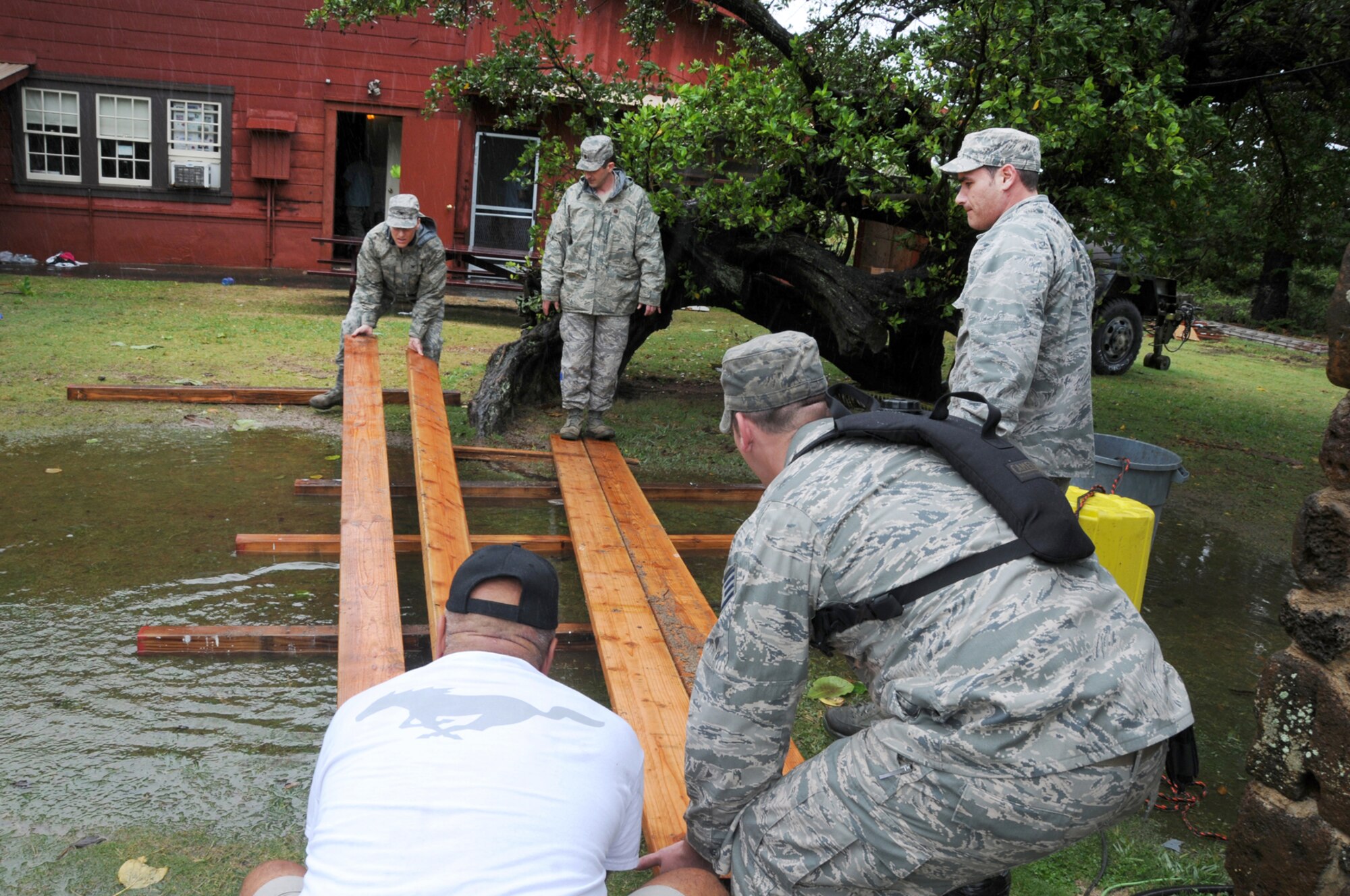 Civil Engineering members build a bridge for patients to walk over after they encountered heavy winds, flooding and torrential downpours in Kapaa, Hawaii during Tropic Care Innovative Readiness Training on March 6. Tropic Care Innovative Readiness Training is comprised of military personnel assets of the U.S. Armed Forces to include Active Duty, Reserve and National Guard members who provide free medical services and conduct deployment and readiness training while forward deployed to the medically underserved island of Kaua'i, Hawaii from February 26 through March 10.  (National Guard photo by Tech. Sgt. Melissa E. Chatham) (released)