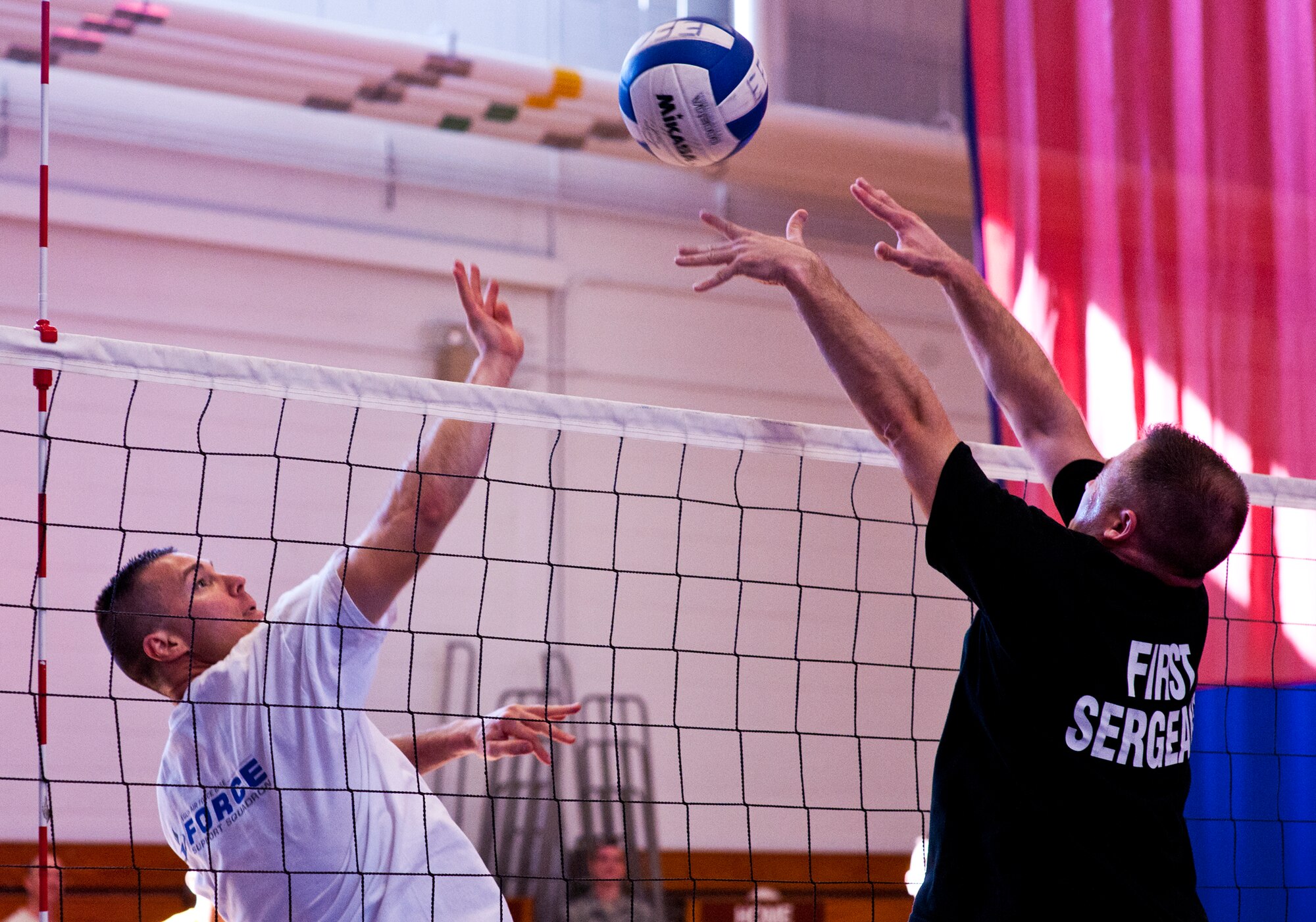 A commander and a first sergeant battle for the ball at the net during their volleyball game March 16 at Eglin Air Force Base, Fla.  The commanders took the win in the closest of three volleyball games pitting officers and enlisted Airmen.  The officers swept all three games with the Company Grade Officers Council and the Eagles also winning.  (U.S. Air Force photo/Samuel King Jr.)