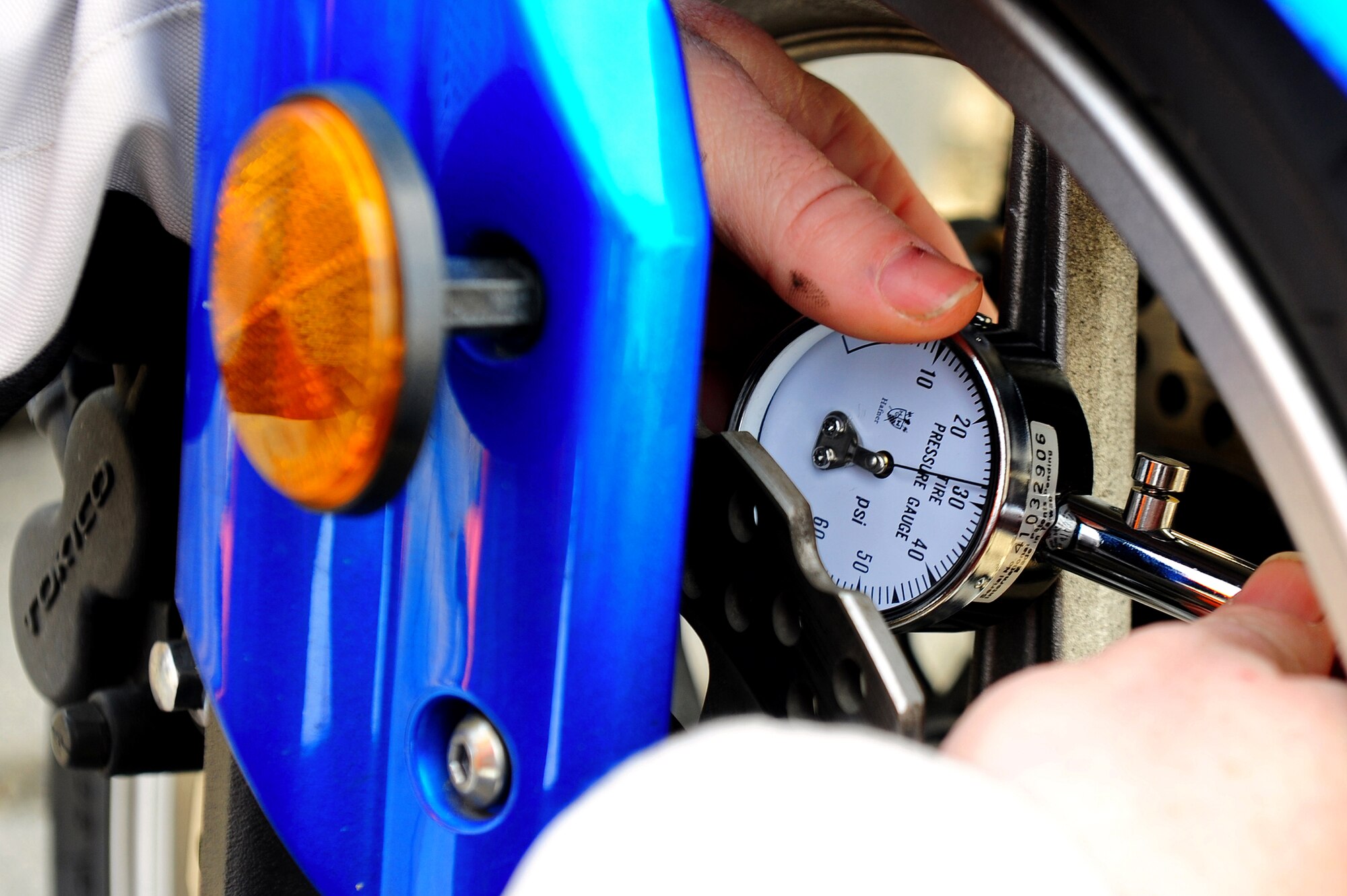 Air Force Tech. Sgt. Monty Nixon, 86th Aircraft Maintenance Squadron maintainer, checks his motorcycle tire pressure using an air compressor during Motorcycle Safety Day, Ramstein Air Base, Germany, March 17, 2012. The safety day was held for the 86th Maintenance Group to promote safe motorcycle practices and raise camaraderie amongst the participants. (U.S. Air Force photo/Airman Brea Miller)