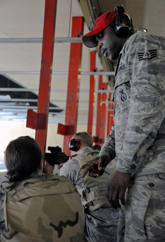 Staff Sgt. Raymond Billups, 11th Security Forces Group combat arms instructor, gives pointers to a Combat Arms Training and Maintenance (CATM) refresher-course student at the Andrews Firing Range Feb. 14. Refresher classes consist of students who need to re-qualify on their weapon for pre-deployment and security forces augmentee purposes. (U.S. Air Force photo/Airman 1st Class Lindsey A. Beadle)