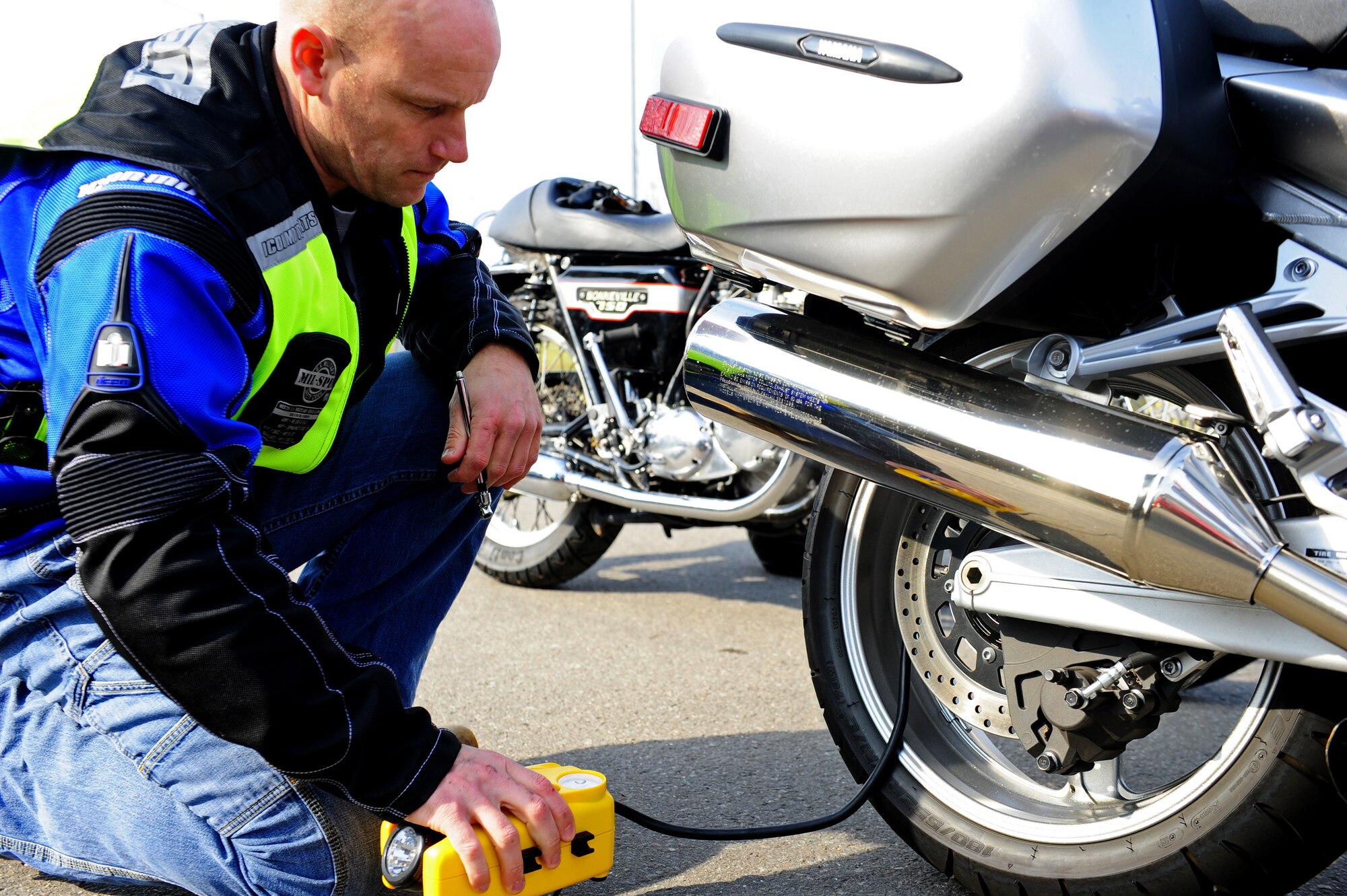 Air Force Chief Master Sgt. William Shields, 86th Aircraft Maintenance Squadron superintendent, checks his motorcycle tire pressure using an air compressor during Motorcycle Safety Day, Ramstein Air Base, Germany, March 17, 2012. The safety day was held for the 86th Maintenance Group to promote safe motorcycle practices and raise camaraderie amongst the participants. (U.S. Air Force photo/Airman Brea Miller)