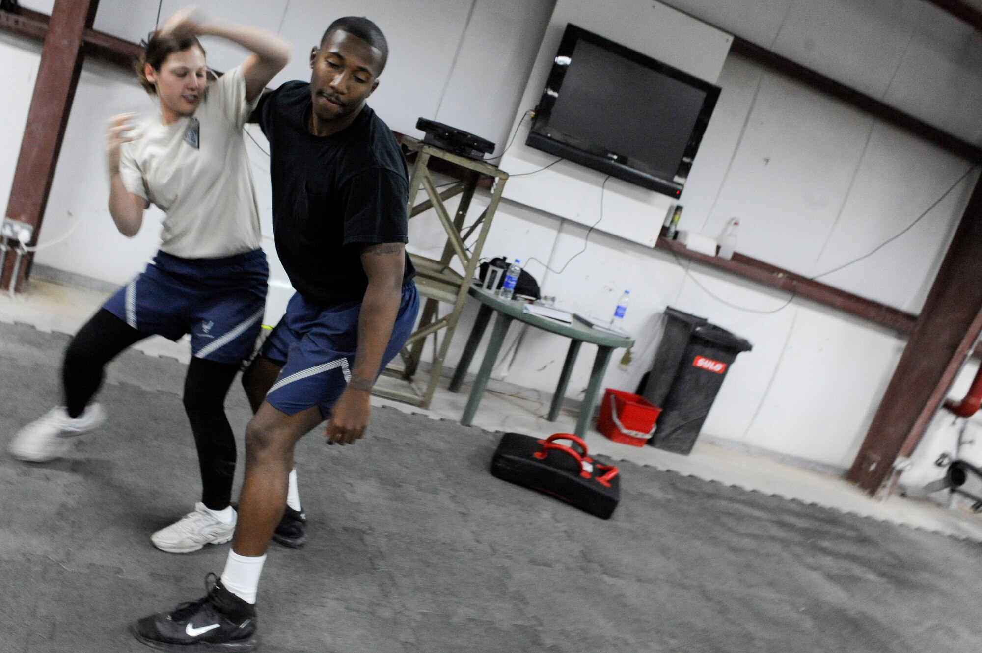 SOUTHWEST ASIA -- Staff Sgt. Stephanie Blank and Senior Airman Norvell Cooper, 332nd Expeditionary Security Forces Squadron members, demonstrate how to escape a choke hold during a Krav Maga class at an undisclosed location in Southwest Asia, March 14, 2012. The class instructors demonstrated each maneuver before the class practiced them. Blank and Cooper are deployed from Mountain Home Air Force Base, Idaho. She is a native of Peoria, Ill., and he is a native of Richmond, Va. (U.S. Air Force Photo by Staff Sgt. Joshua J. Garcia)