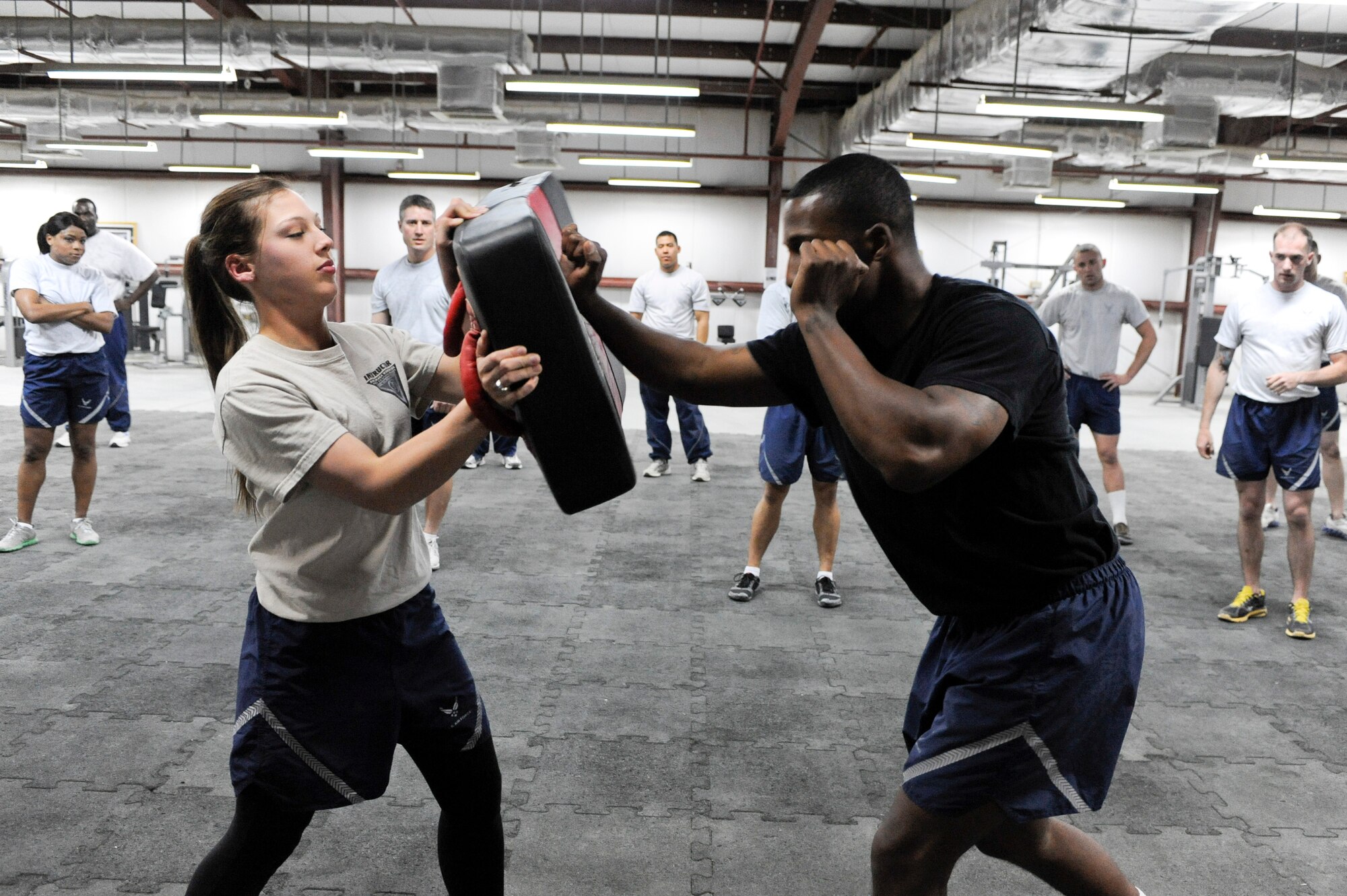 SOUTHWEST ASIA -- Staff Sgt. Stephanie Blank and Senior Airman Norvell Cooper, 332nd Expeditionary Security Forces Squadron members, demonstrate an open palm thrust during a Krav Maga class at an undisclosed location in Southwest Asia, March 12, 2012. As instructors for the class, Blank and Cooper wore different color shirts to differentiate themselves from students. The class taught 332nd Air Expeditionary Wing Airmen how to defend themselves and how to counter-attack an assailant. Blank and Cooper are deployed from Mountain Home Air Force Base, Idaho. She is a native of Peoria, Ill., and he is a native of Richmond, Va. (U.S. Air Force Photo by Staff Sgt. Joshua J. Garcia)