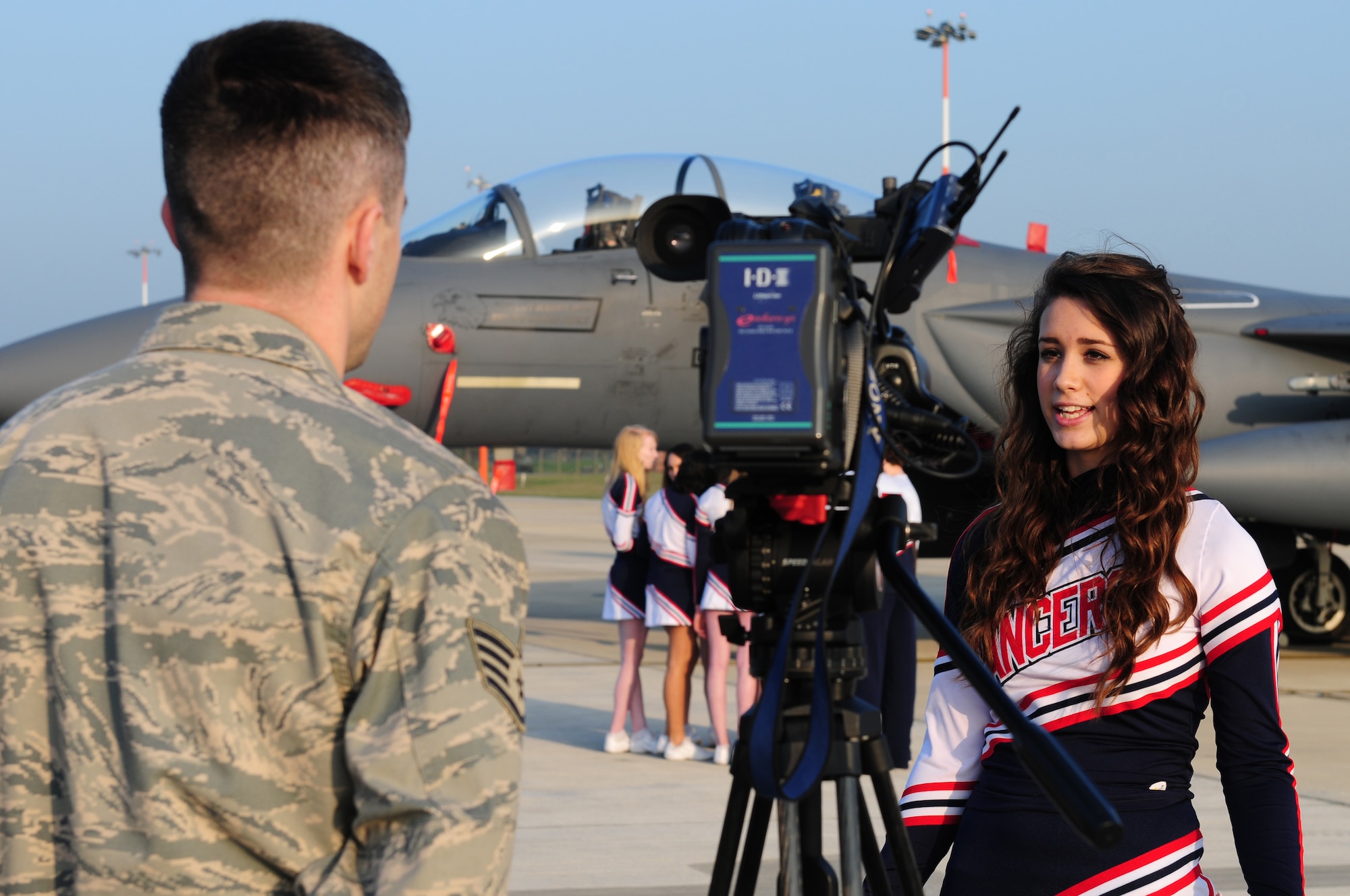 ROYAL AIR FORCE LAKENHEATH, England -- Alexa Gorham, Lakenheath High School cheerleader, is interviewed by Staff Sgt. Lance Daigle, Armed Forces Network U.K. broadcaster, on the flightline March 15, 2012. The LHS cheerleaders won first place during the 2012 Department of Defense Dependent Schools Division 1 European Championships in Wiesbaden, Germany, Feb. 25, 2012. In addition to their first place win, they also brought home the Spirit Award, which is given to the school with the most spirit, and four individual All Tournament Cheerleader awards. (U.S. Air Force photo by Senior Airman Lausanne Morgan)