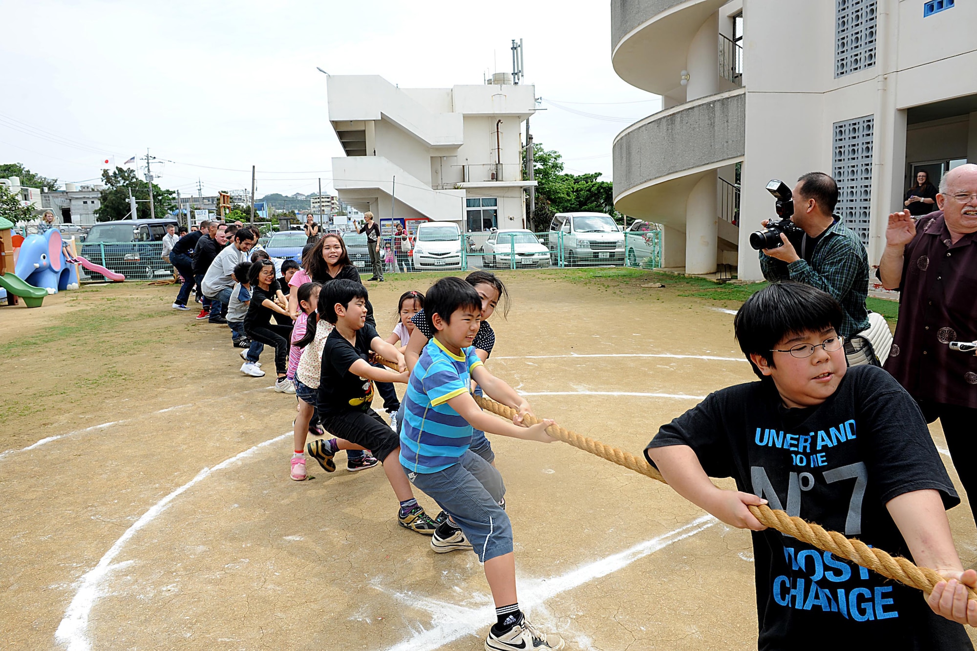 U.S. service members and children participate in a tug of war during a friendship day at Chatan Town's Busy Bee School on Okinawa, March 17, 2012. Unlike American schools, attended Monday through Friday, students at Busy Bee attend school Monday through Saturday. (U.S. Air Force photo by Airman 1st Class Brooke P. Beers/Released)