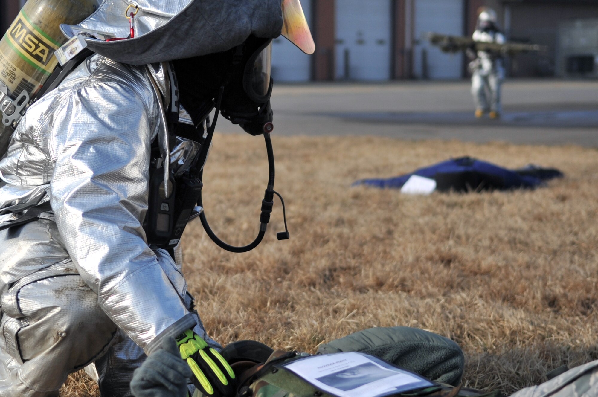 A firefighter from the 51st Civil Engineer Squadron calls for assistance while trying to help an injured Airman during a simulated plane crash at Osan Air Base, March 19, 2012. Team Osan Airmen are participating in operational readiness exercise Beverly Midnight 12-01. (U.S. Air Force photo/Staff Sgt. Craig R. Cisek)