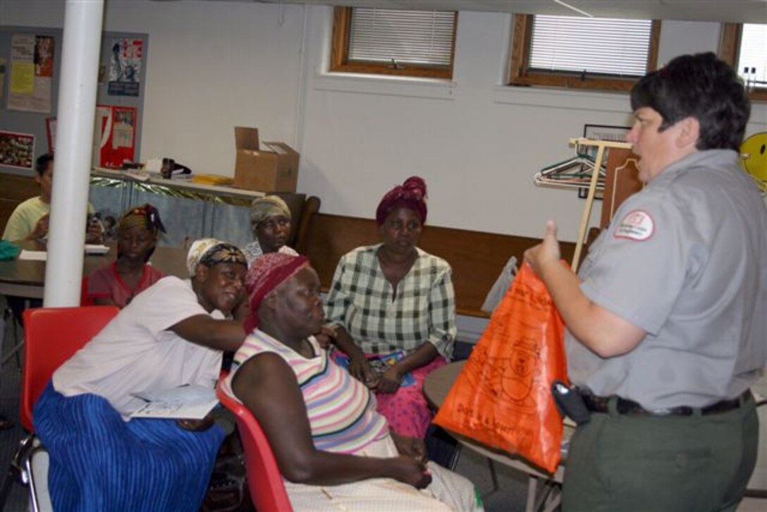 ILLINOIS — Lou Ann McCracken, a natural resources specialist with the U.S. Army Corps of Engineers Mississippi River Project, presents water safety information to local refugees, educating them on hidden dangers in the river.