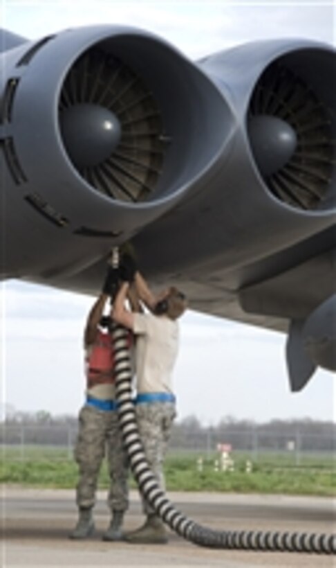 Airman 1st Class Kwann Peters (left) and Senior Airman Bryan Turner, both with the 20th Aircraft Maintenance Unit, disconnect an aircraft hose from a B-52H Stratofortress engine at Barksdale Air Force Base, La., on March 6, 2012.  The aircraft hose and its attached apparatus are used to start only one engine, which in turn starts the rest of the engines on the aircraft.  