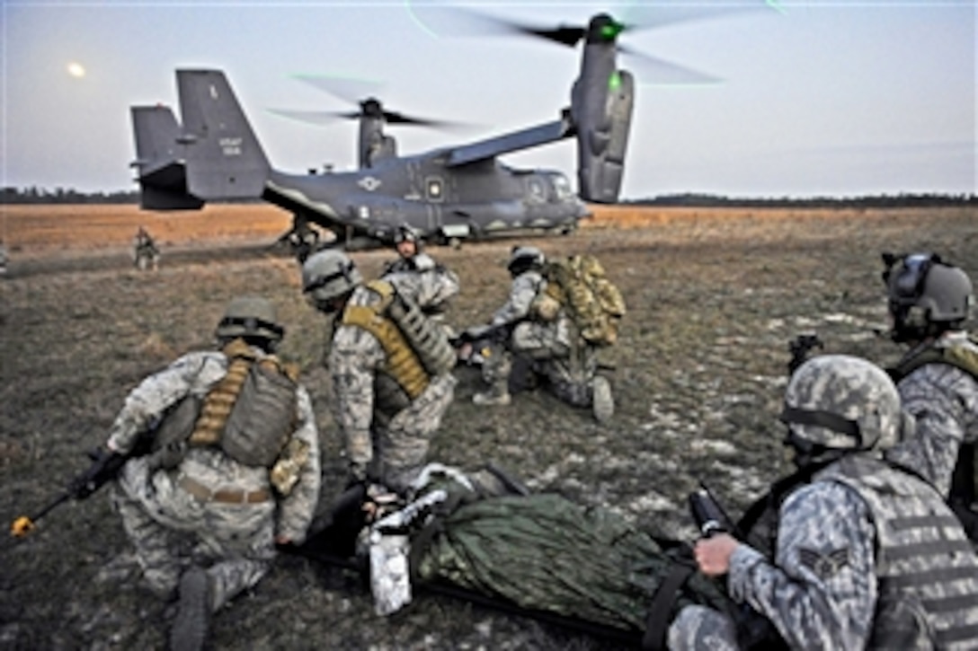 U.S. Air Force airmen wait to load a simulated aircraft crash victim onto a CV-22 Osprey aircraft during Emerald Warrior at Hurlbert Field, Fla., on March 7, 2012.  The exercise's primary purpose is to train with special operations components in urban and irregular warfare settings to support combatant commanders in theater campaigns.  
