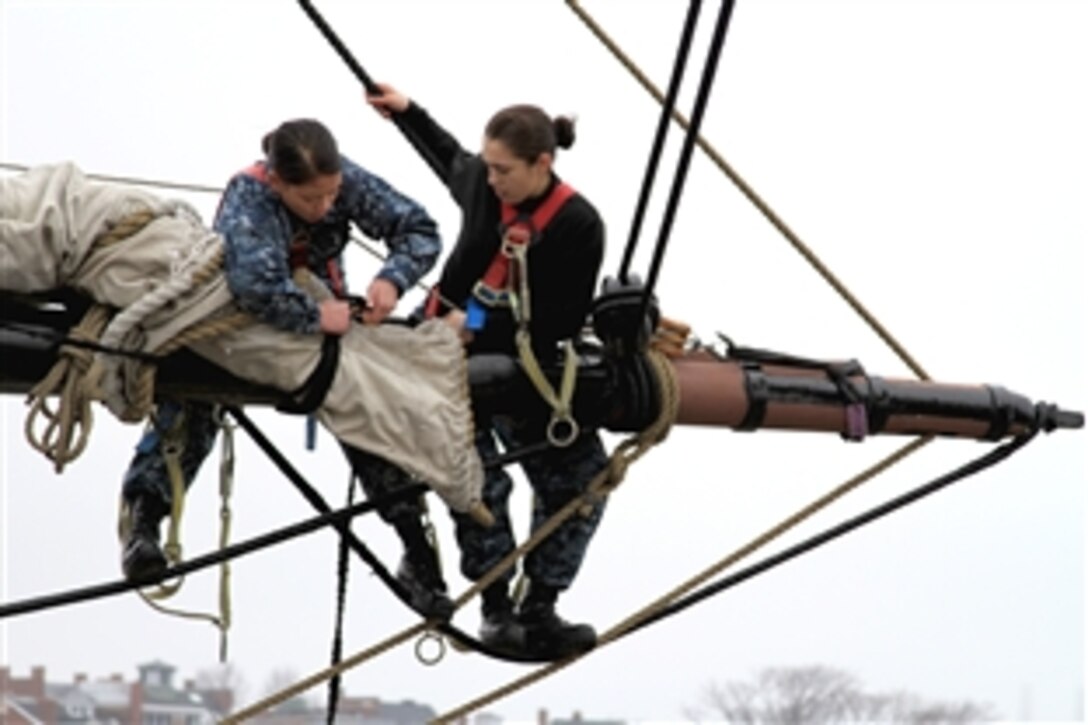 U.S. Navy Petty Officers Sang Nguyen, left, and Shelia Guerrero place the sail on the yard of the mizzen mast aboard USS Constitution in Charleston, Mass., March 14, 2012. U.S. Navy sailors assigned to the Constitution routinely work to improve seamanship skills to prepare for ceremonies marking the bicentennial of the War of 1812. 