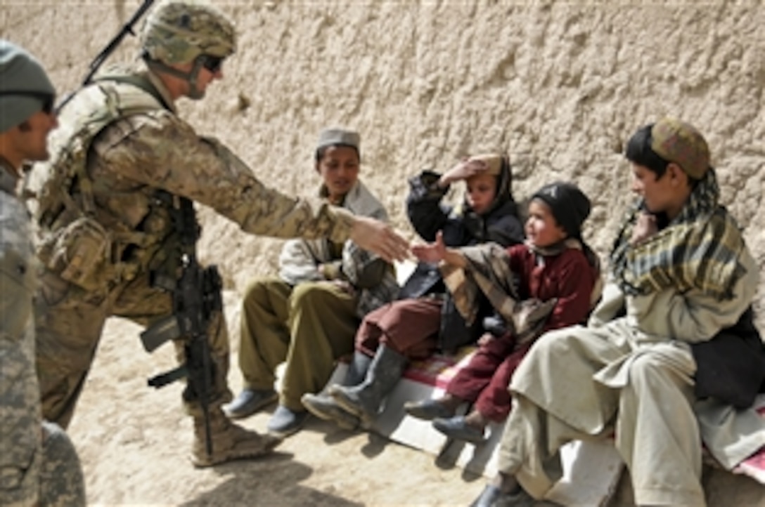 U.S. Army 2nd Lt. Jeffery Russell greets Afghan children in the village Sader Kheyl, Afghanistan, March 17, 2012. Russell is a platoon leader assigned to Company B, 3rd Battalion, 509th Infantry Regiment.