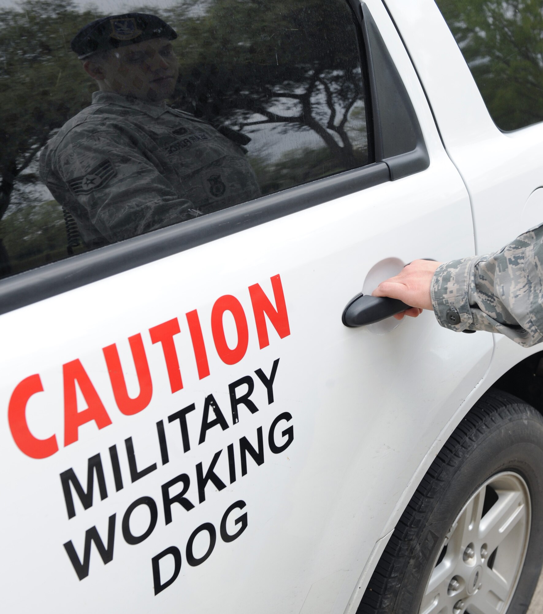 Staff Sgt. Jeffrey Lincoln, 2nd Security Forces Squadron Military Working Dog handler, prepares to let out his canine Rufus during a spot inspection at the main gate on Barksdale Air Force Base, La., March 15. Lincoln and Rufus spend more than 60 hours together throughout the week training, performing vehicle searches, responding to calls and patrolling the base and flightline. (U.S. Air Force photo/Senior Airman Amber Ashcraft) (RELEASED)
