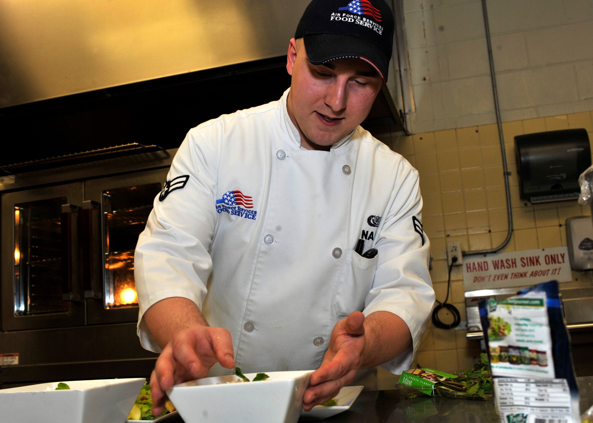 Airman 1st Class Elijah Nash puts a garnish on a bowl of banana pudding during the Iron Chef competition at the Dining Facility Mar. 16, 2012, at Dover Air Force Base, Del. (U.S. Air Force photo by Tech. Sgt. Chuck Walker)