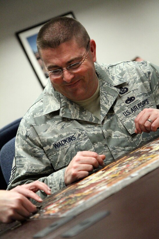 Senior Master Sgt. Todd Wadkins, wing safety NCOIC, enjoys helping put the final pieces of a puzzle together during a team building exercise on Wingman's Day.  All 932nd Airlift Wing units and personnel participated several hours in various team building exercises at the March weekend training drill.  (U.S. Air Force photo/Tech. Sgt. Christopher Parr) 