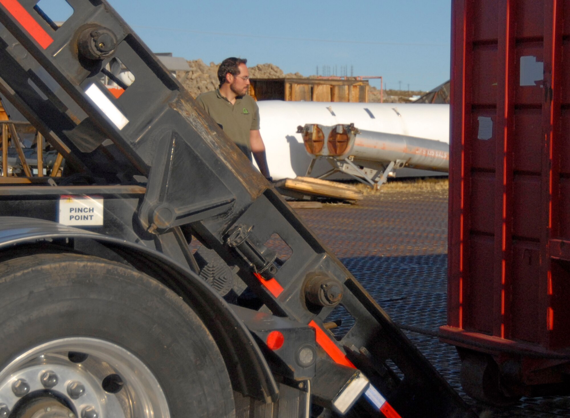 Kevin Herrera, Alpha Technical Services Corporation project manager, watches as a load of non-recyclable materials is lifted onto a flatbed truck March 15 at the Air Force Flight Test Center Museum storage facility.  The museum staff began the cleanup effort six months ago when the facility was flagged during an internal audit. The project is expected to continue over the next two years and significantly boost participation in the base's recycling program. (Air Force Photo by Laura Mowry)