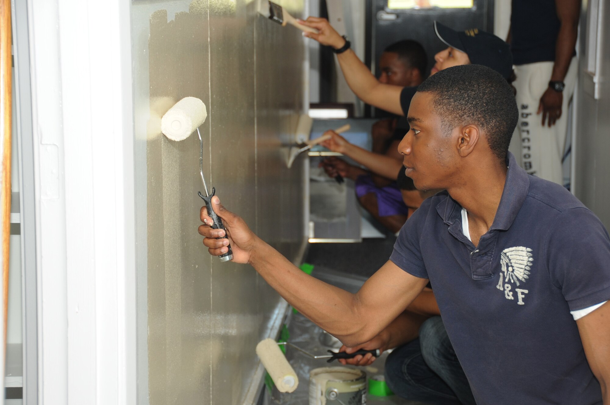 Airman 1st Class Ja’Mario Powell, 334th Training Squadron, paints a hallway in the Keesler Heritage Center on Meadows Drive March 16, 2012, Keesler Air Force Base, Miss.  The 334th TRS provided 45 student and staff volunteers to renovate the inside of the building by filing photos, cleaning the rooms, disassembling old shelving, taking out trash, and organizing rooms and putting together displays.  (U.S. Air Force photo by Kemberly Groue)