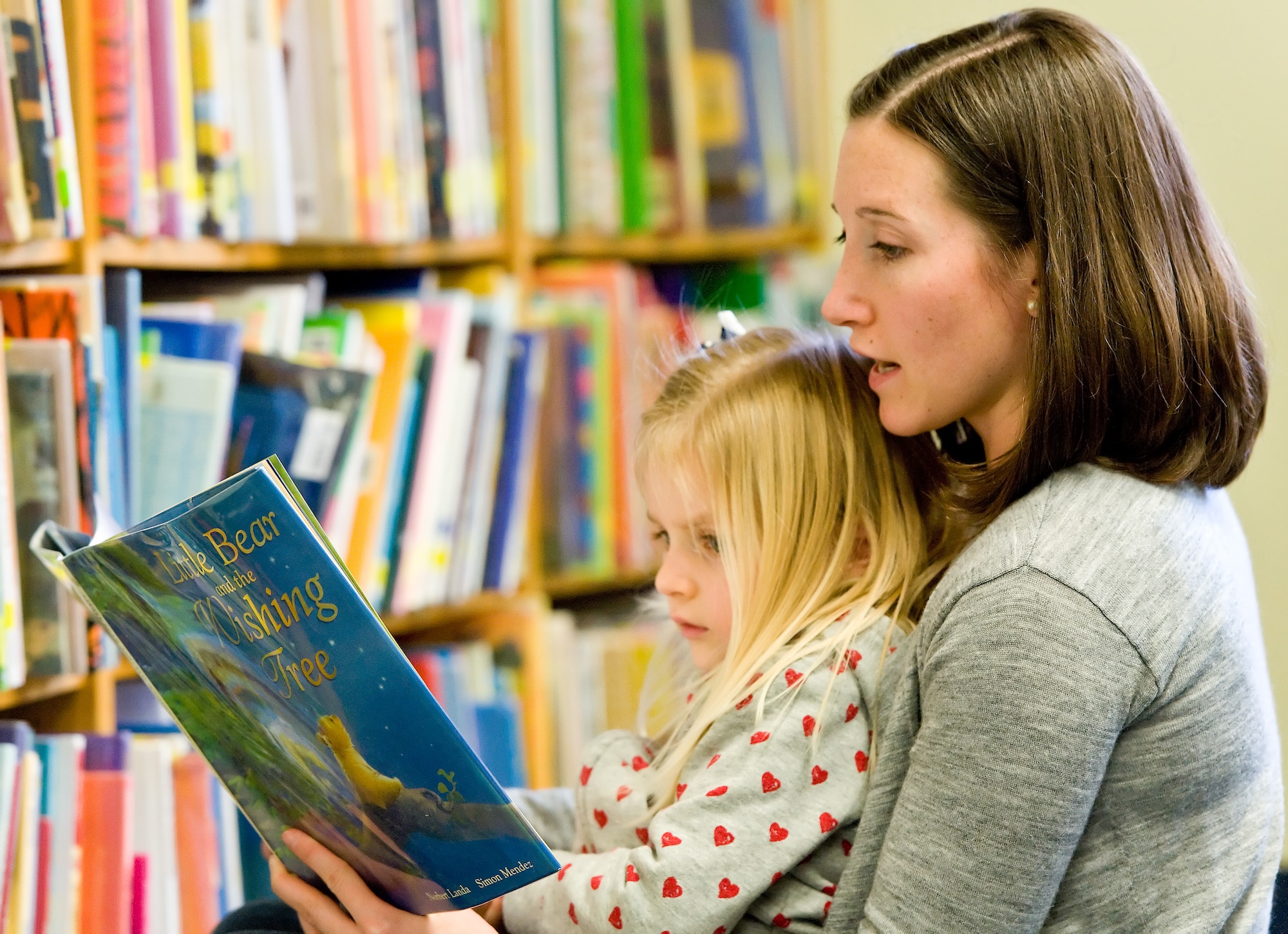 Natalie Tutsky, 3, and Anne Tutsky, her mother, read a book after story time  March 7, 2012, at the Dover Air Force Base, Del., Base Library. Story time is held every Wednesday at 10:30 a.m. and is open to all dependent children of military members. (U.S. Air Force photo by Roland Balik)