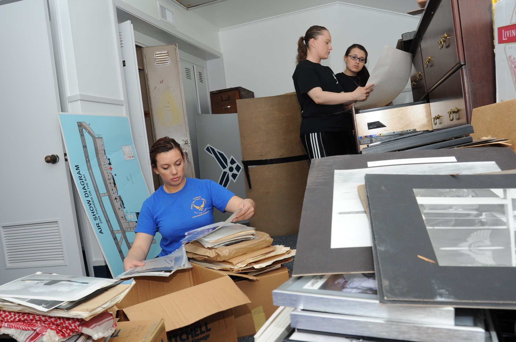 Airman Basic Autumn Bustillo, Staff Sgt. Alexandria Valdez, and Airman 1st Class Alexa Mojarro, 334th Training Squadron, sort through historical images at the Keesler Heritage Center on Meadows Drive March 16, 2012, Keesler Air Force Base, Miss.  The 334th TRS provided 45 student and staff volunteers to renovate the inside of the building by filing photos, cleaning the rooms, disassembling old shelving, taking out trash, and organizing rooms and putting together displays.  (U.S. Air Force photo by Kemberly Groue)